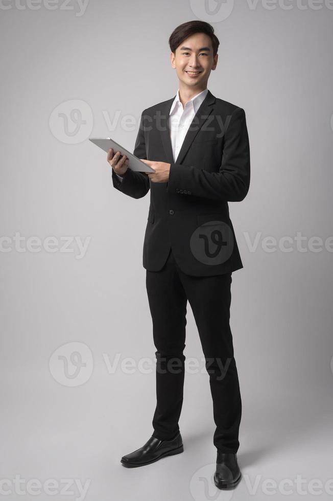 joven empresario vistiendo traje sobre estudio de fondo blanco foto