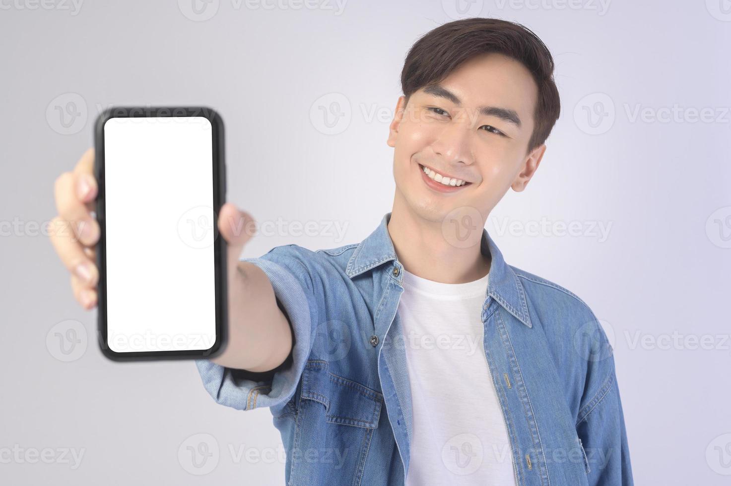 Young asian man using smartphone over white background, technology concept. photo