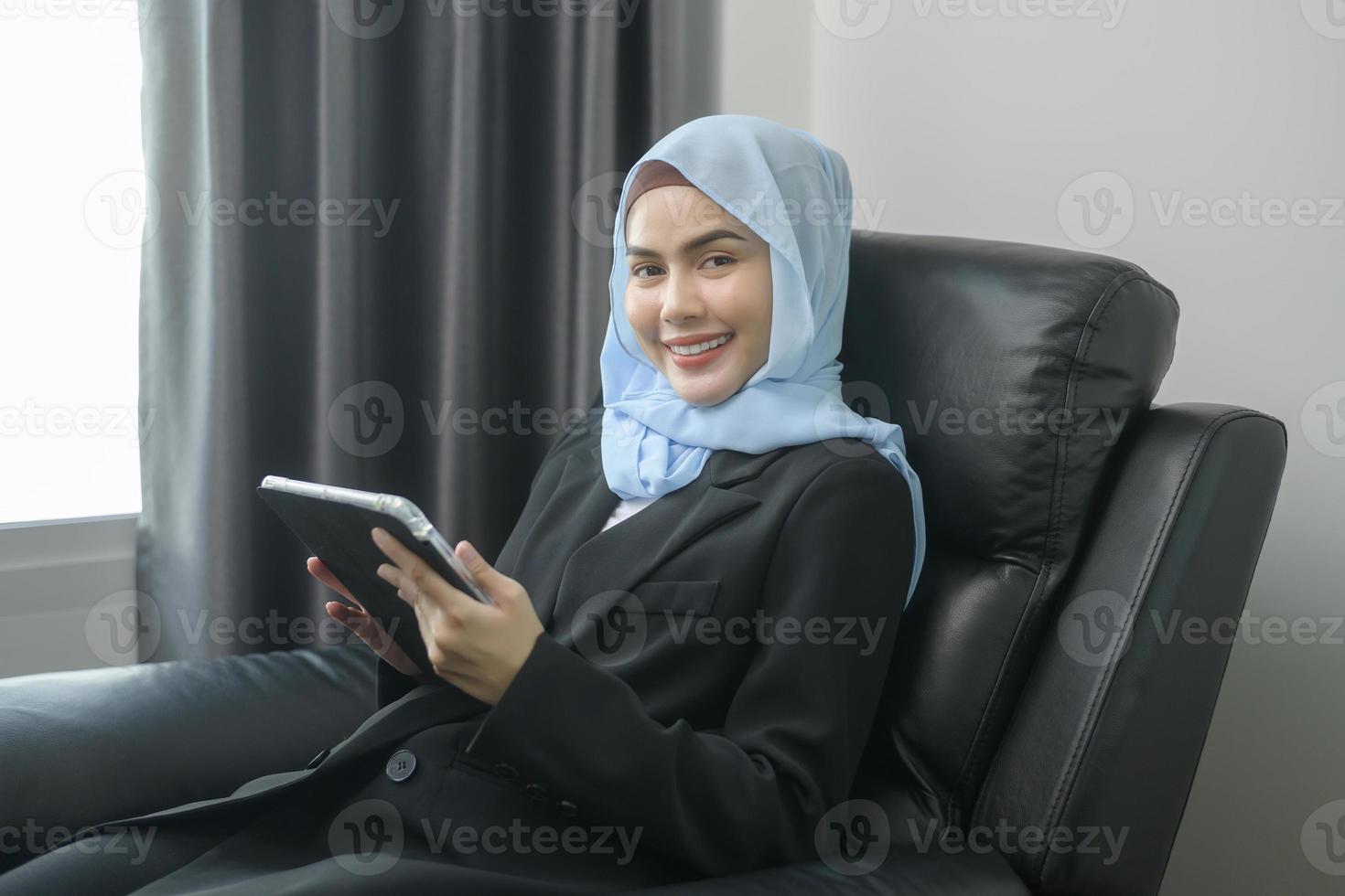 joven mujer de negocios musulmana usando tableta en la oficina moderna foto