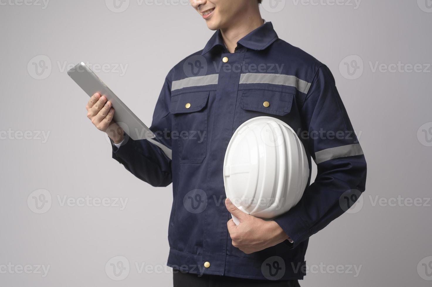 Portrait of male engineer wearing a protective helmet over white background studio. photo