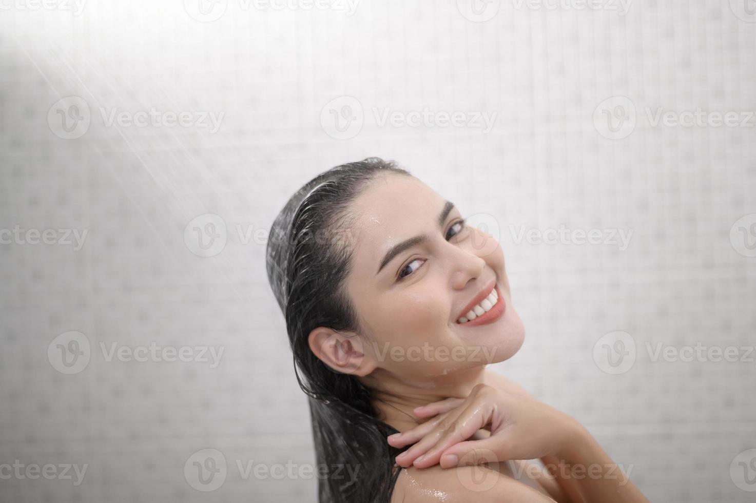 una mujer feliz y hermosa se está duchando foto