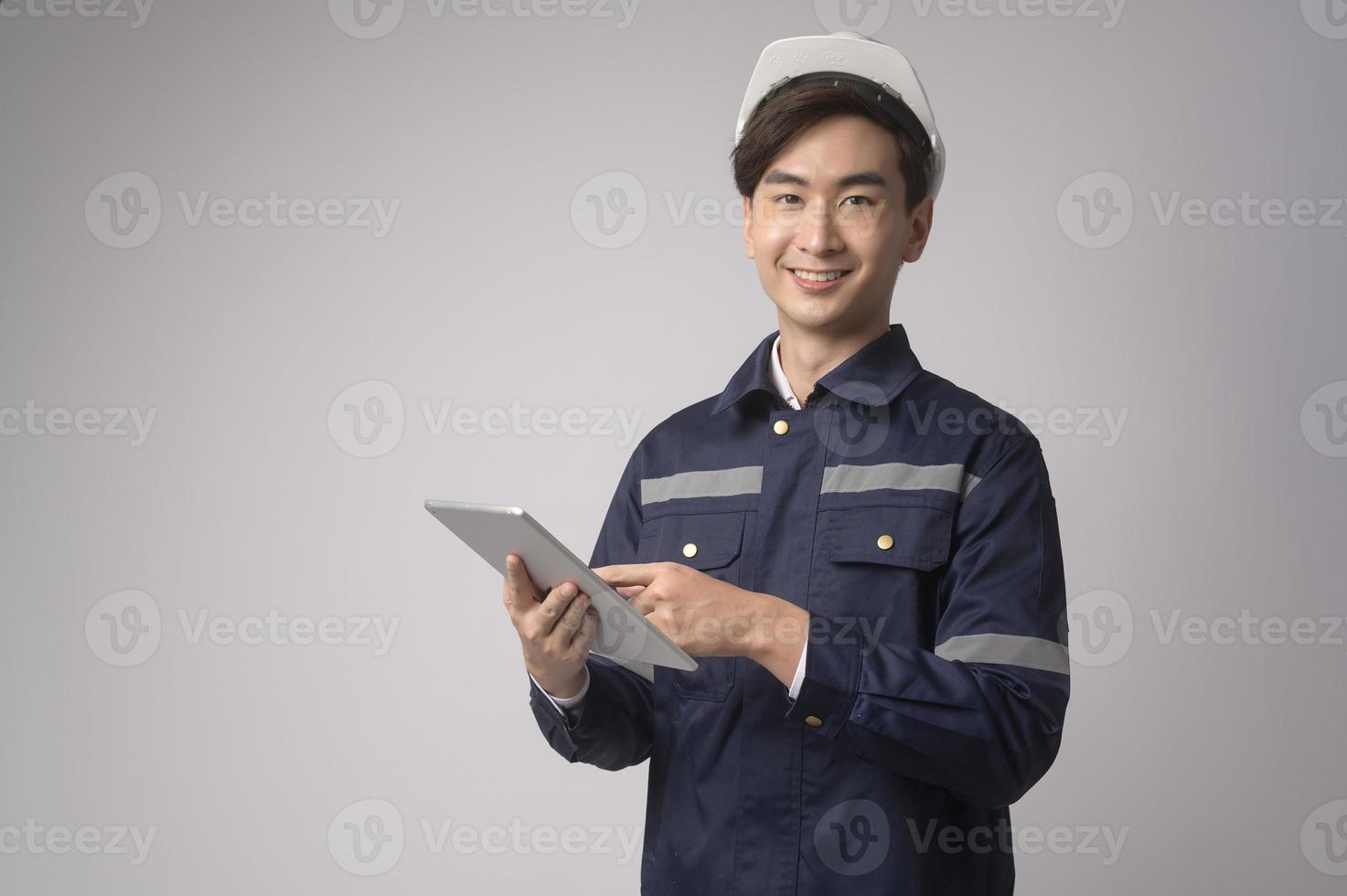 retrato de un ingeniero que lleva un casco protector sobre un estudio de fondo blanco. foto