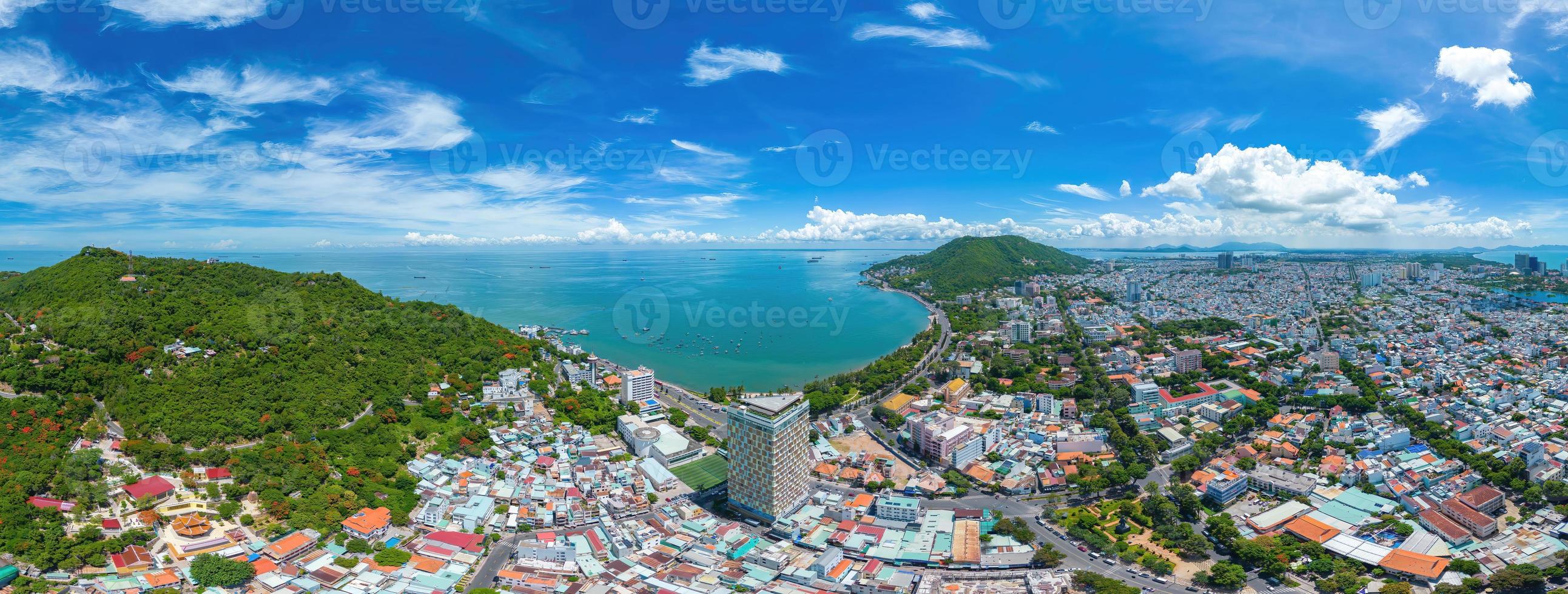 Vung Tau city aerial view with beautiful sunset and so many boats. Panoramic coastal Vung Tau view from above, with waves, coastline, streets, coconut trees and Tao Phung mountain in Vietnam. photo