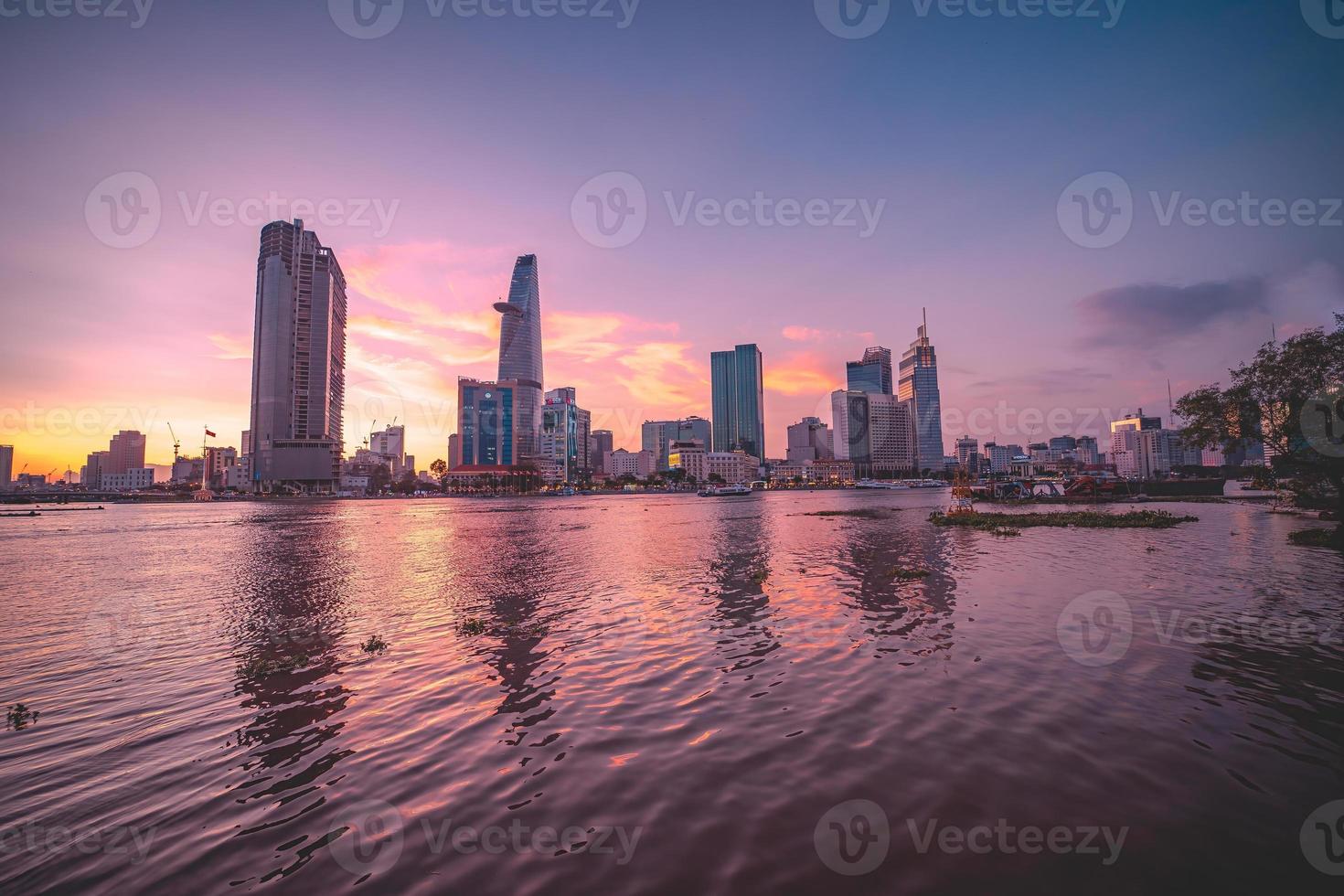 HO CHI MINH, VIETNAM - FEB 13 2022  View of Bitexco Financial Tower building, buildings, roads, Thu Thiem bridge and Saigon river in Ho Chi Minh city in sunset. High quality panorama image. photo