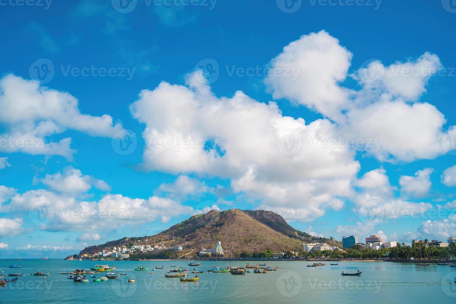 Vung Tau city aerial view with beautiful sunset and so many boats. Panoramic coastal Vung Tau view from above, with waves, coastline, streets, coconut trees and Tao Phung mountain in Vietnam. photo