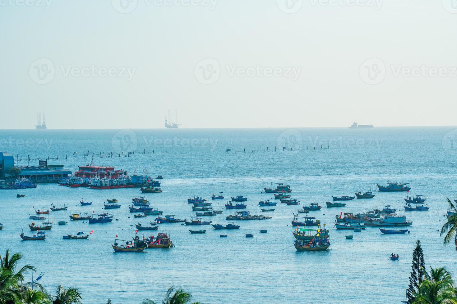 Vung Tau city aerial view with beautiful sunset and so many boats. Panoramic coastal Vung Tau view from above, with waves, coastline, streets, coconut trees and Tao Phung mountain in Vietnam. photo