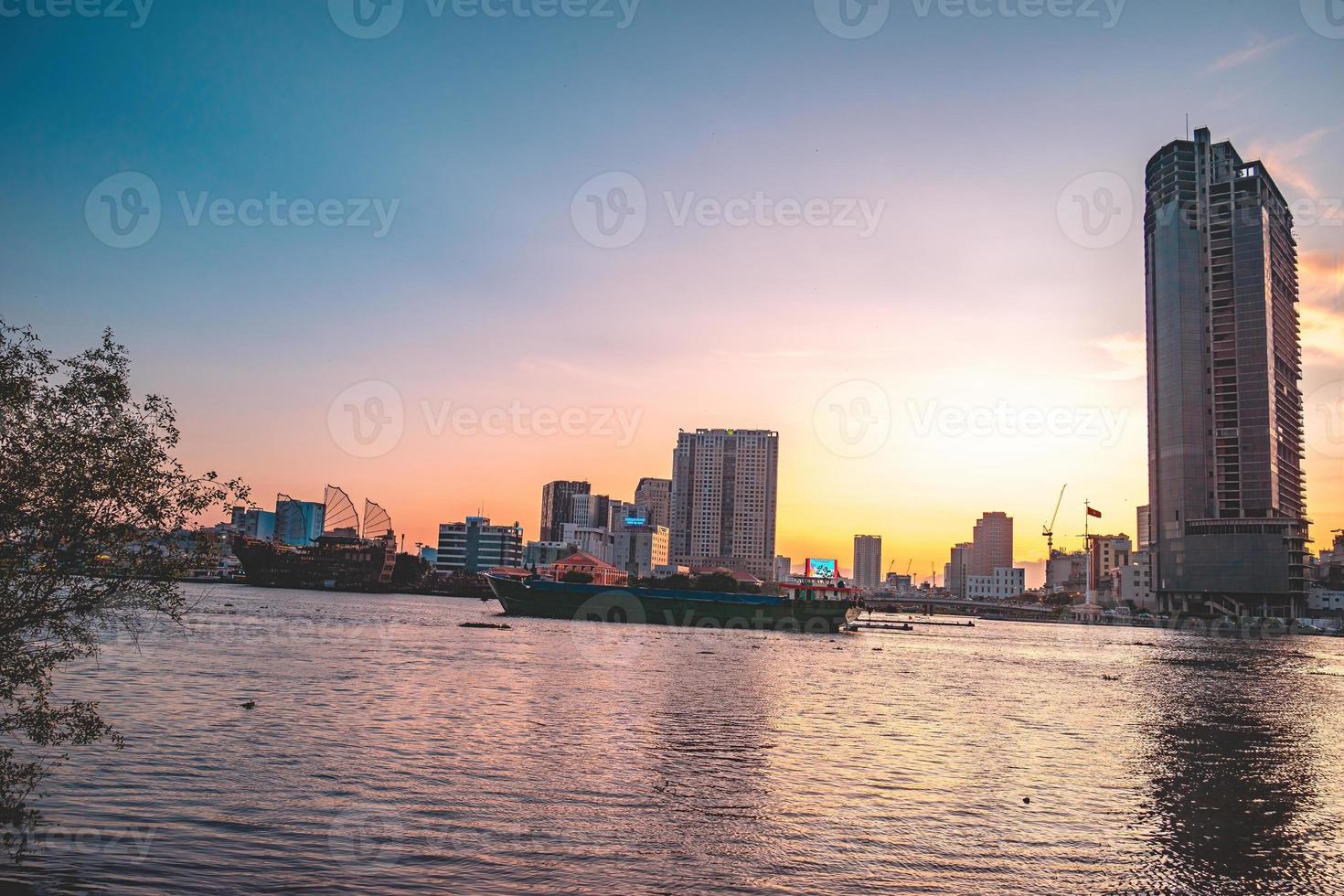 HO CHI MINH, VIETNAM - FEB 13 2022  View of Bitexco Financial Tower building, buildings, roads, Thu Thiem bridge and Saigon river in Ho Chi Minh city in sunset. High quality panorama image. photo