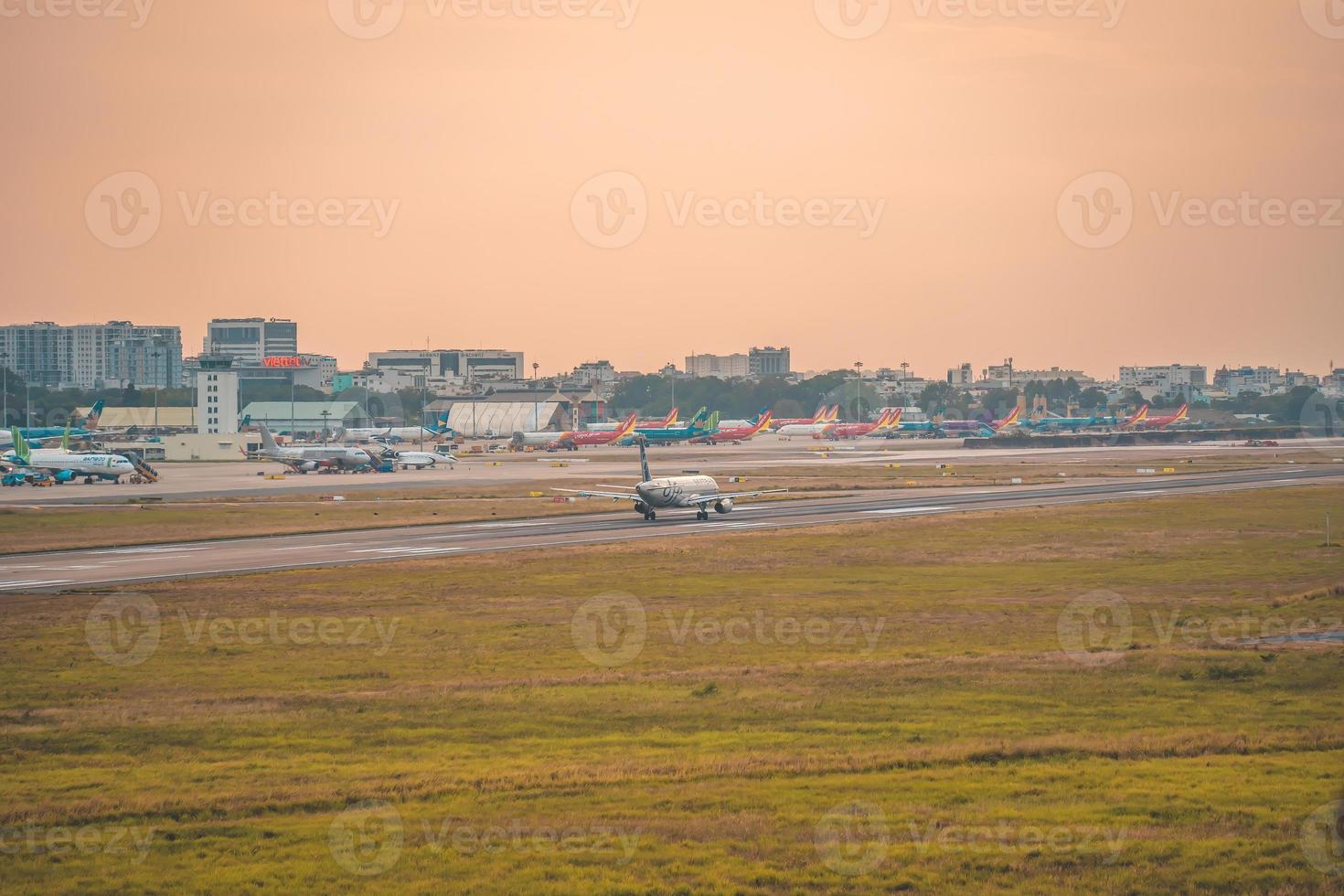 ciudad de ho chi minh, vietnam - 12 de febrero de 2022, un avión vuela sobre áreas urbanas preparando el aterrizaje en el aeropuerto internacional de tan son nhat y despega en el aeropuerto de tsn foto