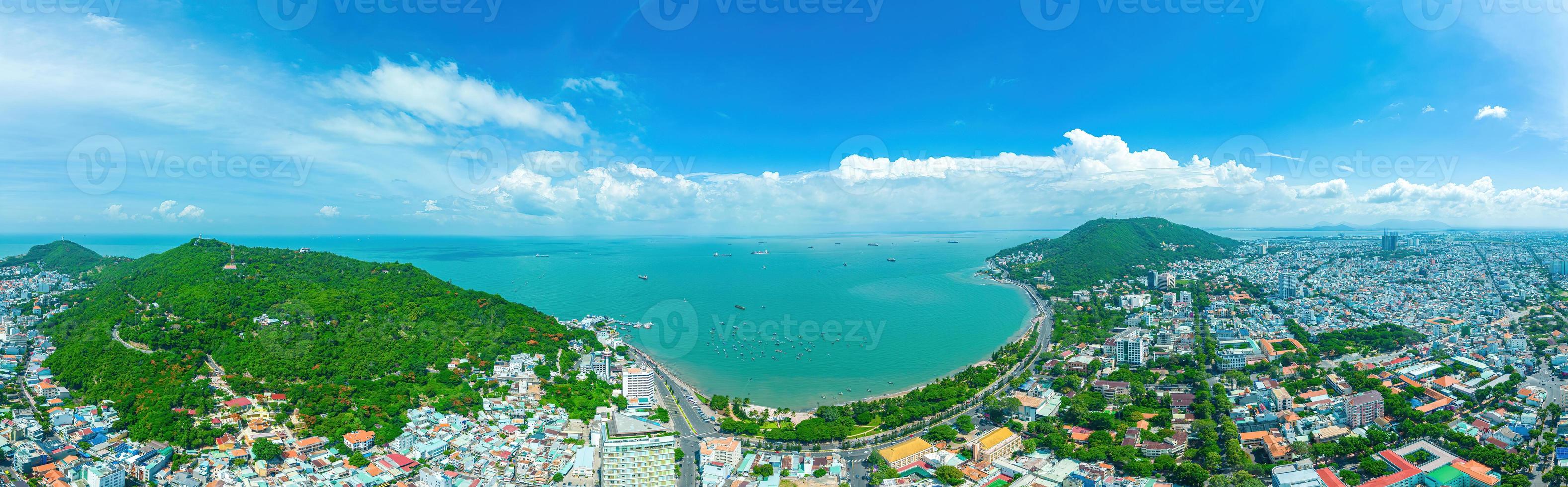 vista aérea de la ciudad de vung tau con hermosa puesta de sol y tantos barcos. vista panorámica costera de vung tau desde arriba, con olas, costa, calles, cocoteros y montaña tao phung en vietnam. foto