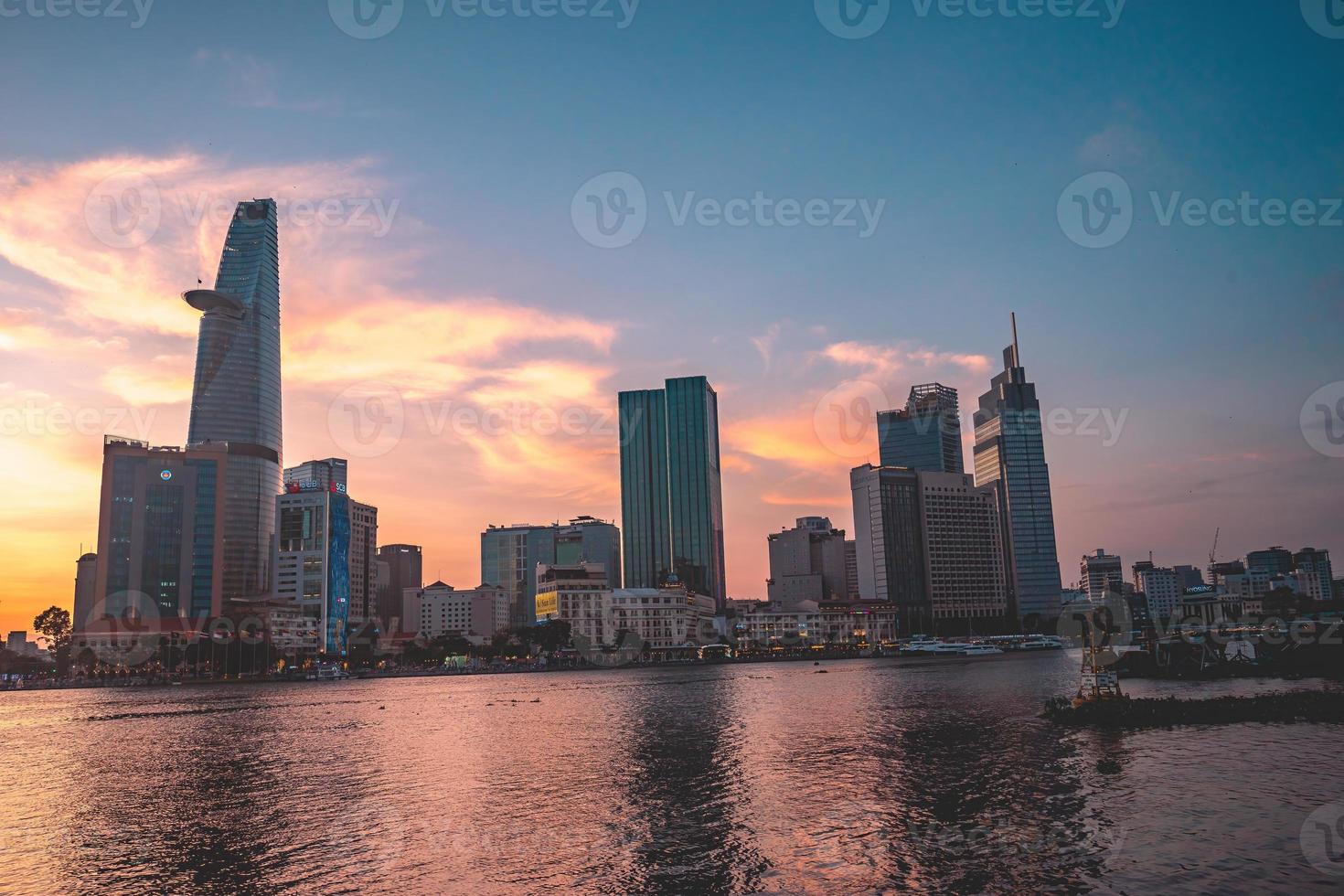 HO CHI MINH, VIETNAM - FEB 13 2022  View of Bitexco Financial Tower building, buildings, roads, Thu Thiem bridge and Saigon river in Ho Chi Minh city in sunset. High quality panorama image. photo