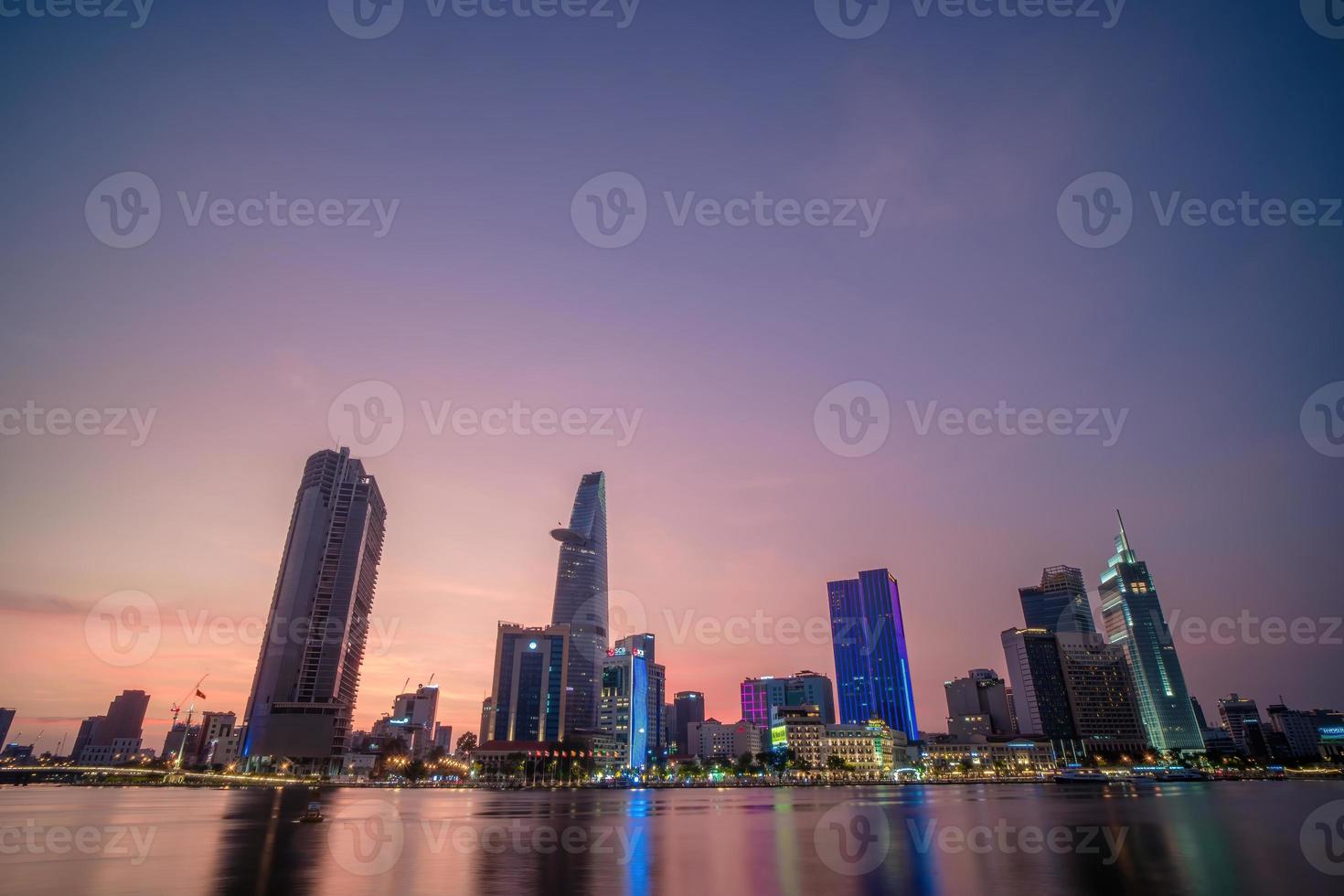 HO CHI MINH, VIETNAM - FEB 19 2022  View of Bitexco Financial Tower building, buildings, roads, Thu Thiem bridge and Saigon river in Ho Chi Minh city in sunset. High quality panorama image. photo