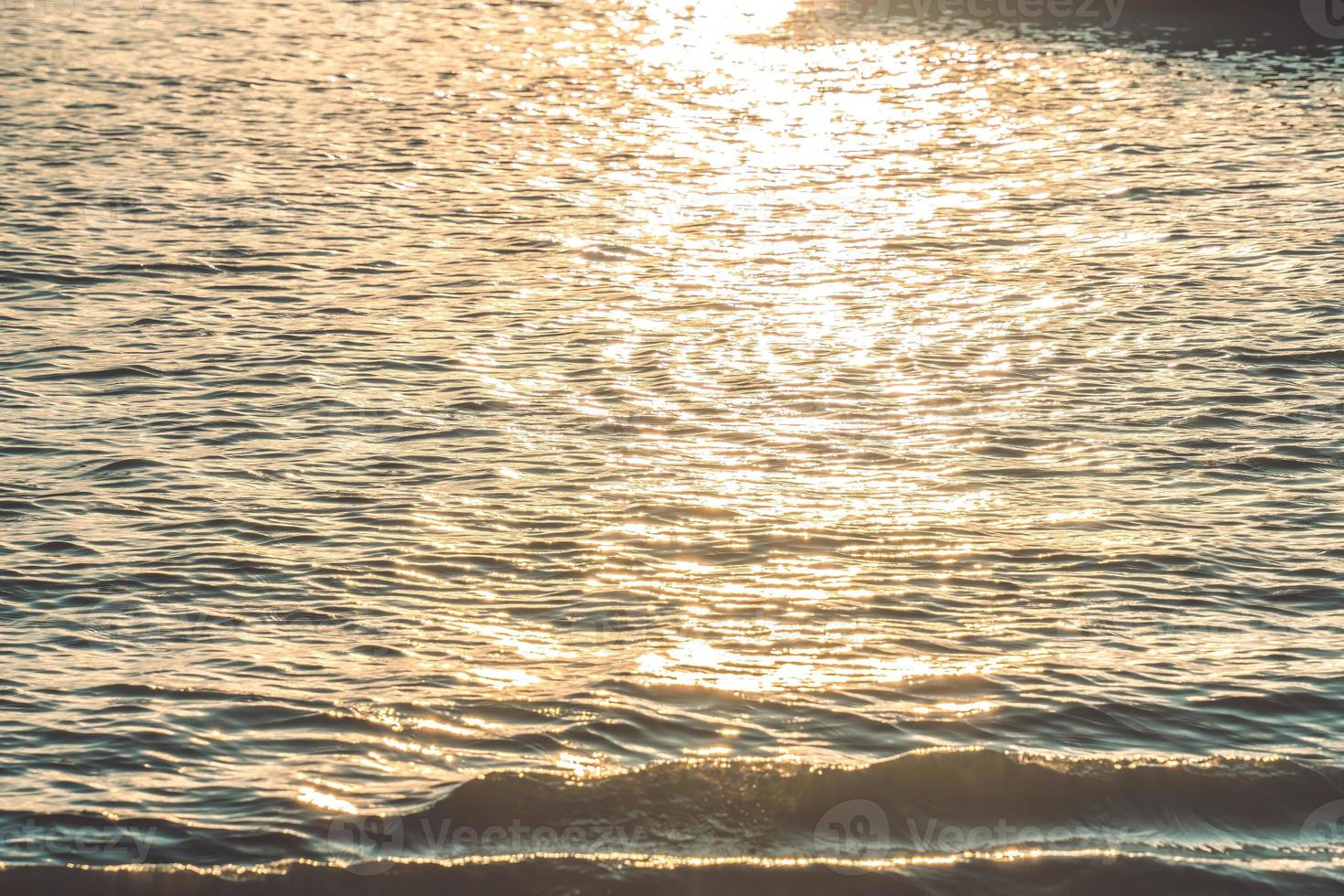 Sunset water reflect ripples at sun light. Abstract golden reflection on water sunset photo