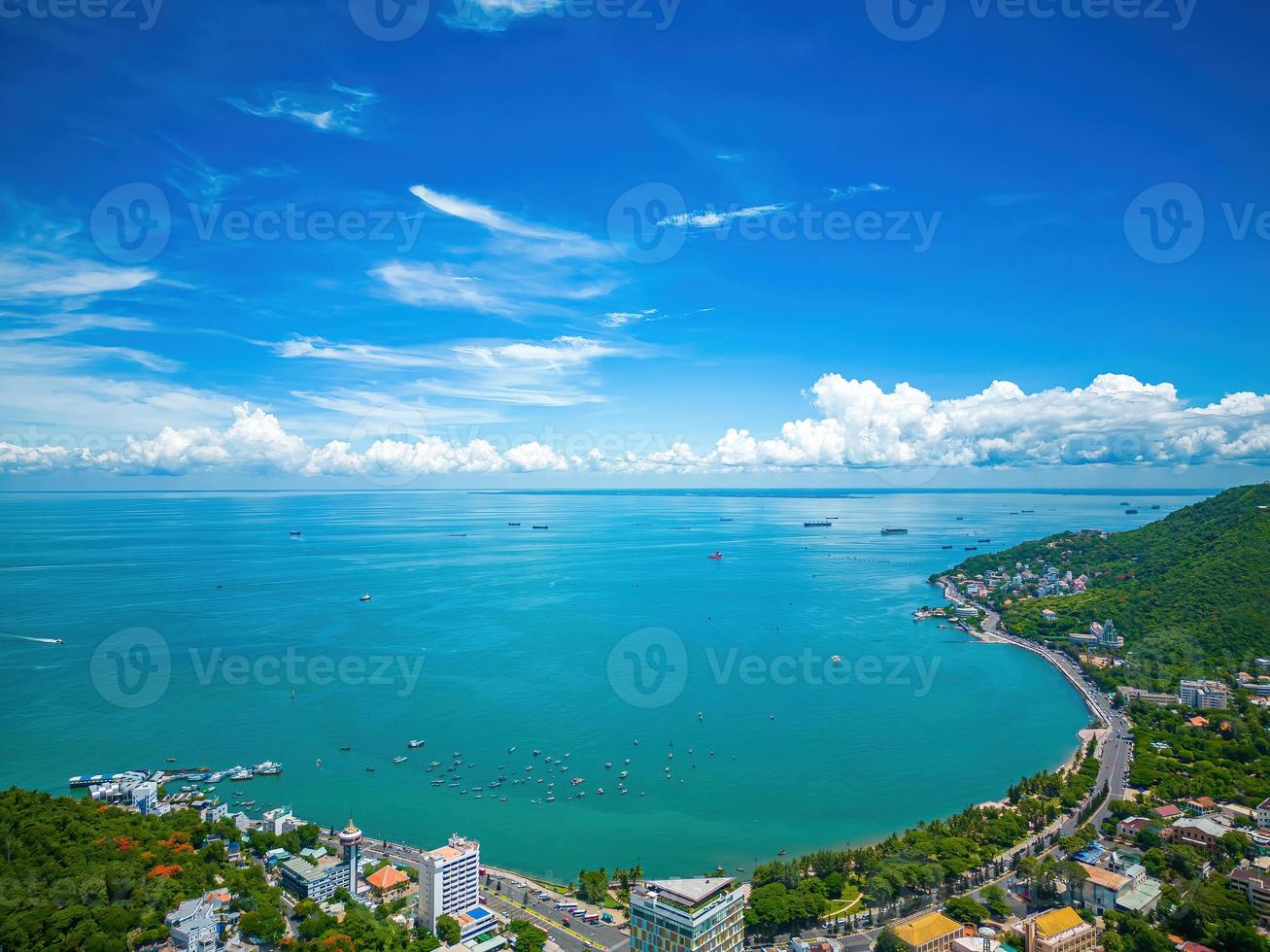 Vung Tau city aerial view with beautiful sunset and so many boats. Panoramic coastal Vung Tau view from above, with waves, coastline, streets, coconut trees and Tao Phung mountain in Vietnam. photo