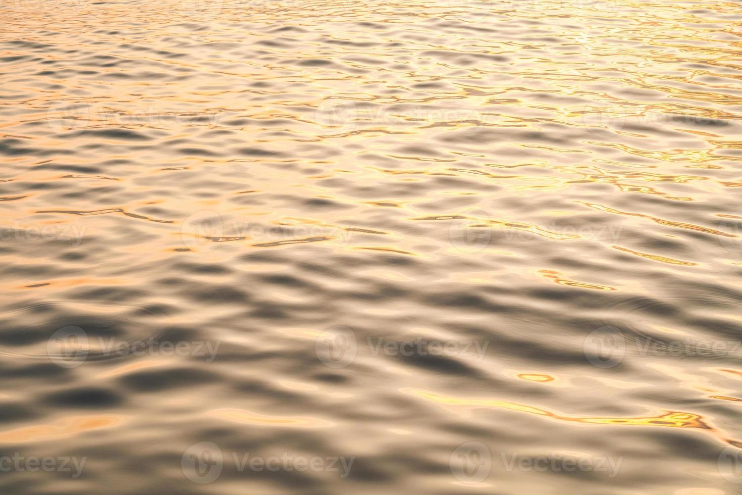 Sunset water reflect ripples at sun light. Abstract golden reflection on water sunset photo