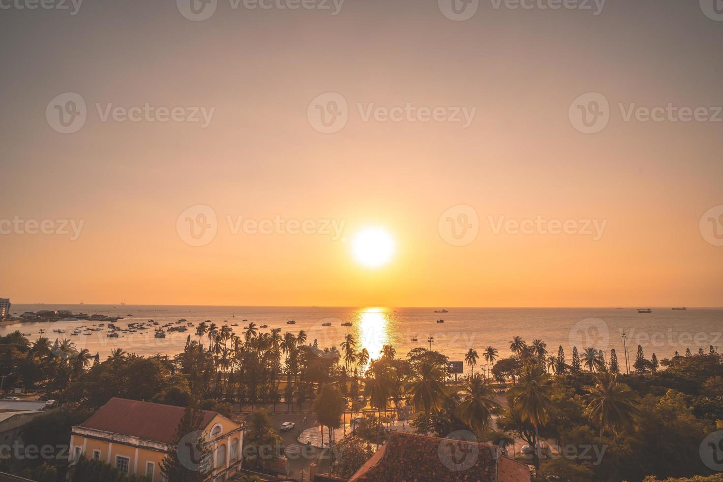 Vung Tau city aerial view with beautiful sunset and so many boats. Panoramic coastal Vung Tau view from above, with waves, coastline, streets, coconut trees and Tao Phung mountain in Vietnam. photo