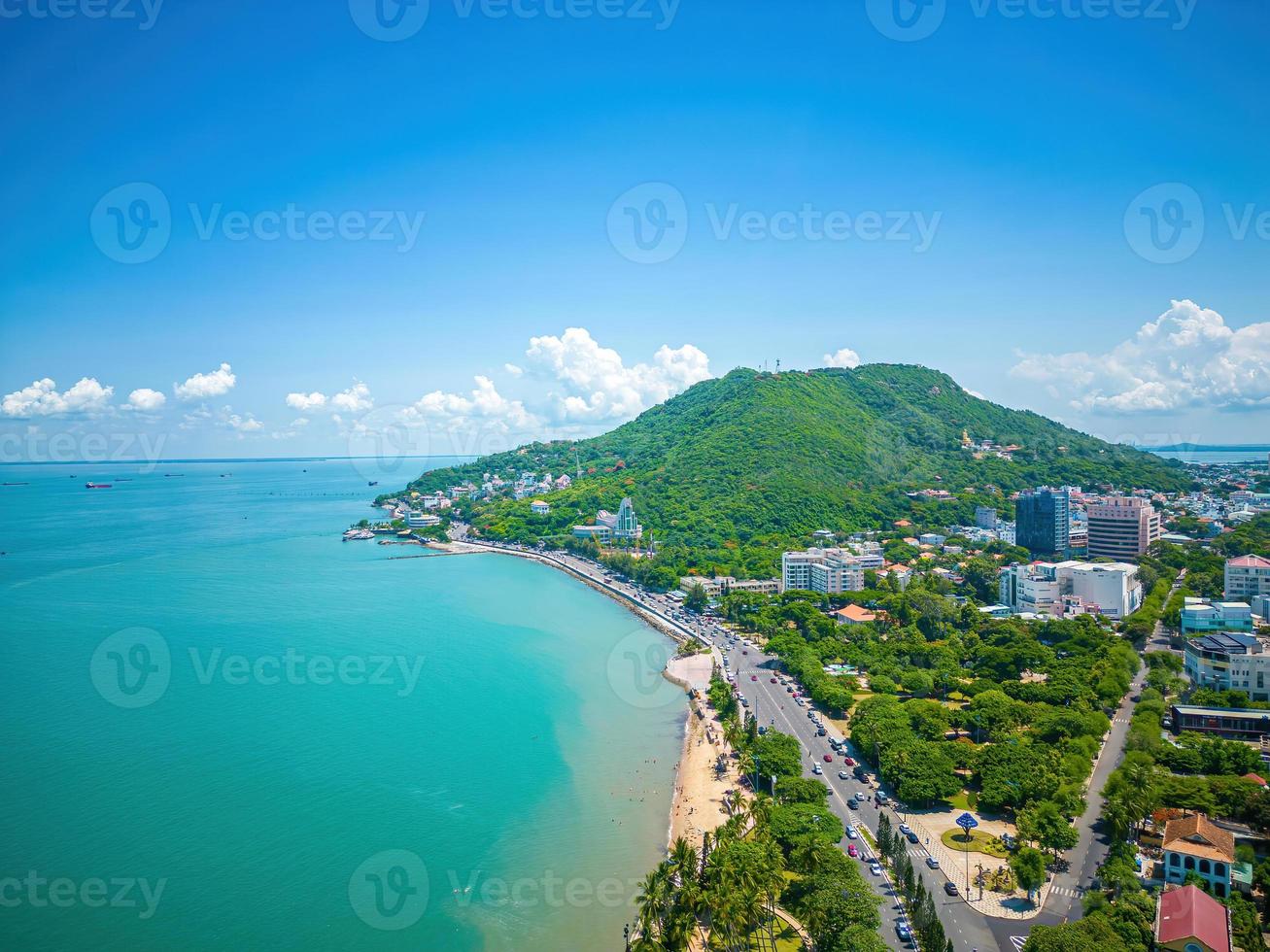 Vung Tau city aerial view with beautiful sunset and so many boats. Panoramic coastal Vung Tau view from above, with waves, coastline, streets, coconut trees and Tao Phung mountain in Vietnam. photo