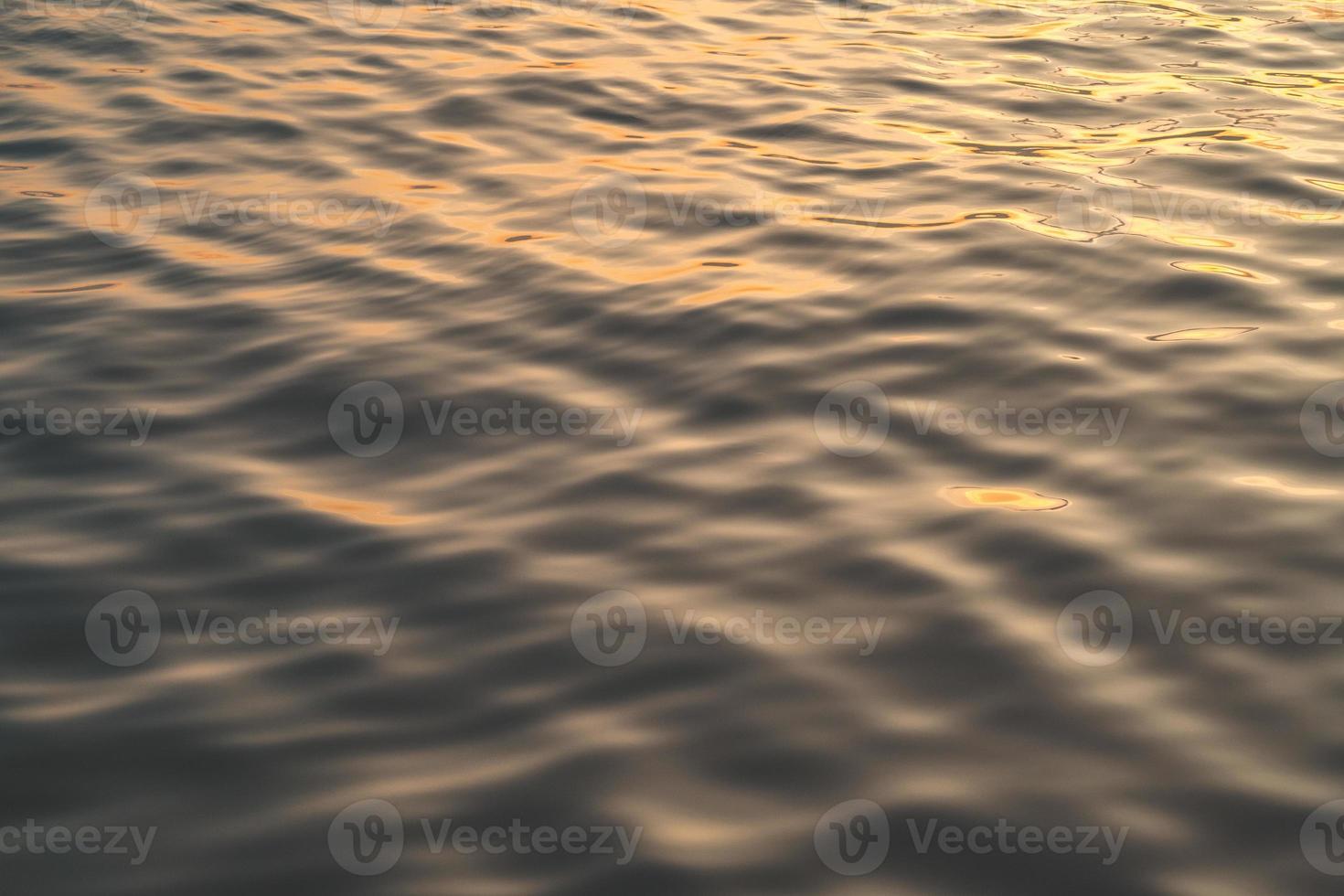 Sunset water reflect ripples at sun light. Abstract golden reflection on water sunset photo