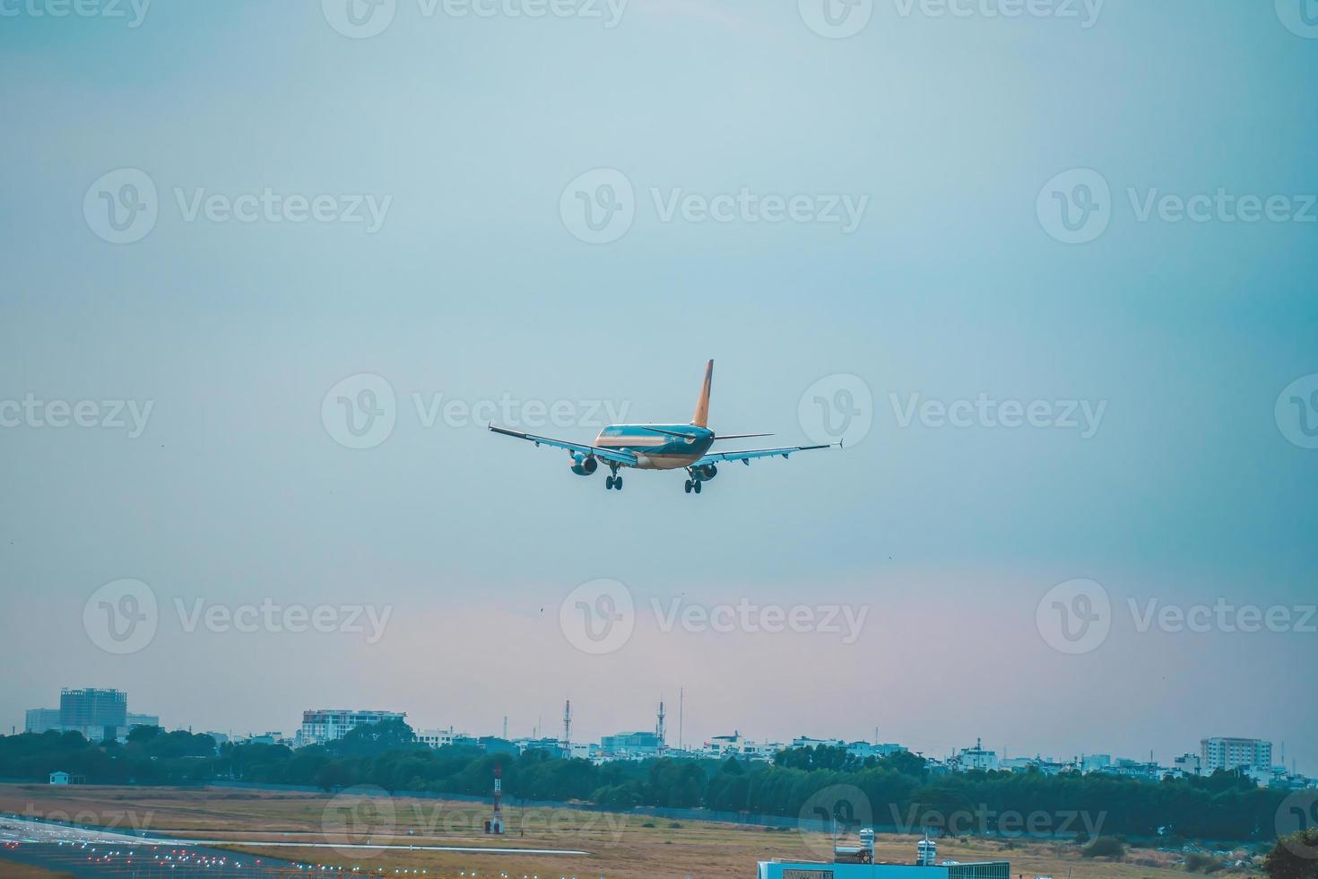 ciudad de ho chi minh, vietnam - 12 de febrero de 2022, un avión vuela sobre áreas urbanas preparando el aterrizaje en el aeropuerto internacional de tan son nhat y despega en el aeropuerto de tsn foto