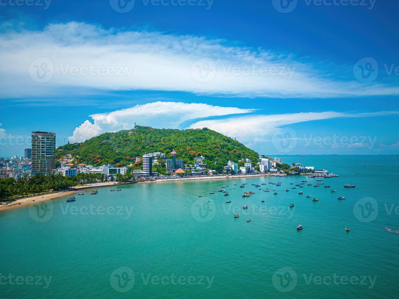 Vung Tau city aerial view with beautiful sunset and so many boats. Panoramic coastal Vung Tau view from above, with waves, coastline, streets, coconut trees and Tao Phung mountain in Vietnam. photo