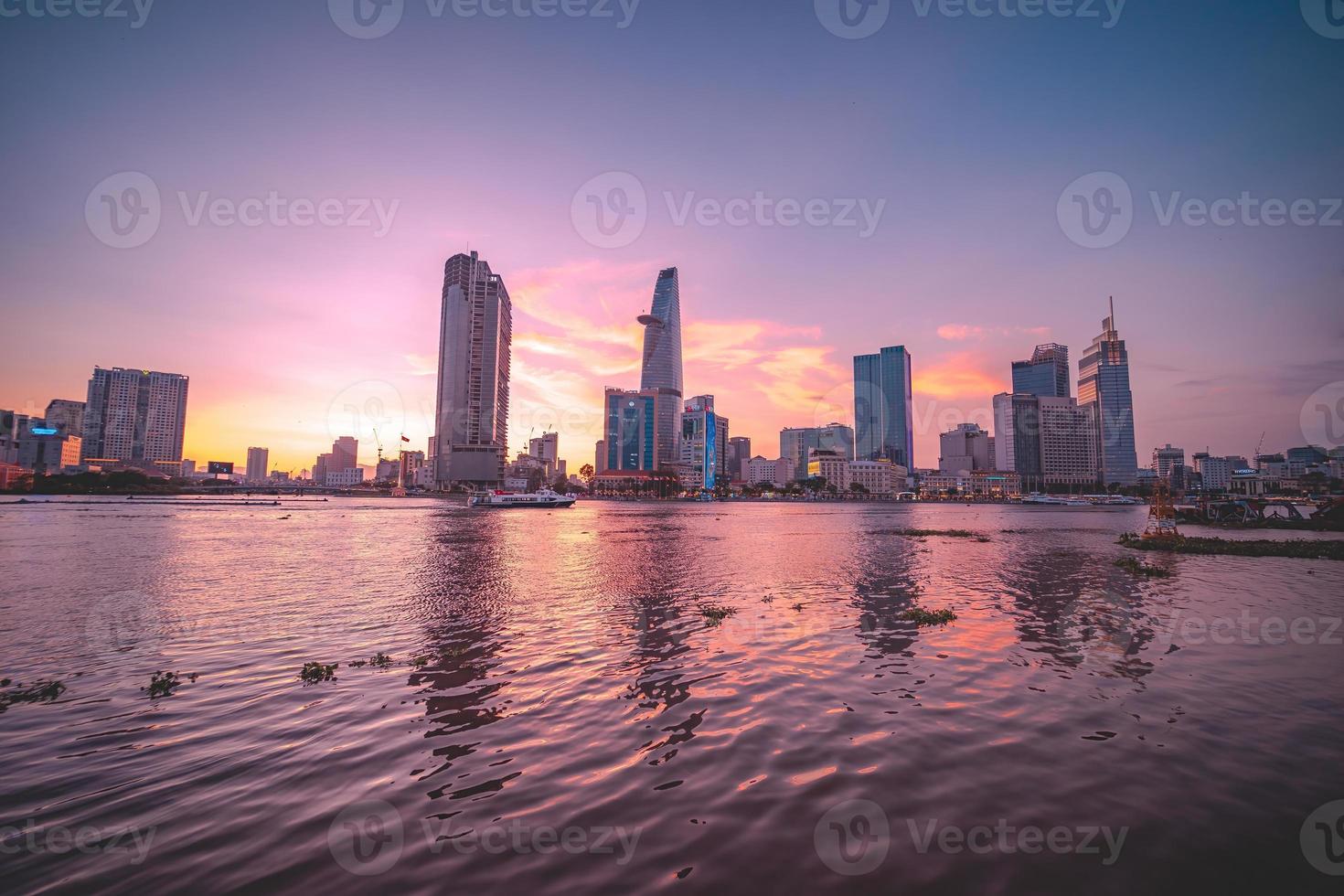 HO CHI MINH, VIETNAM - FEB 13 2022  View of Bitexco Financial Tower building, buildings, roads, Thu Thiem bridge and Saigon river in Ho Chi Minh city in sunset. High quality panorama image. photo