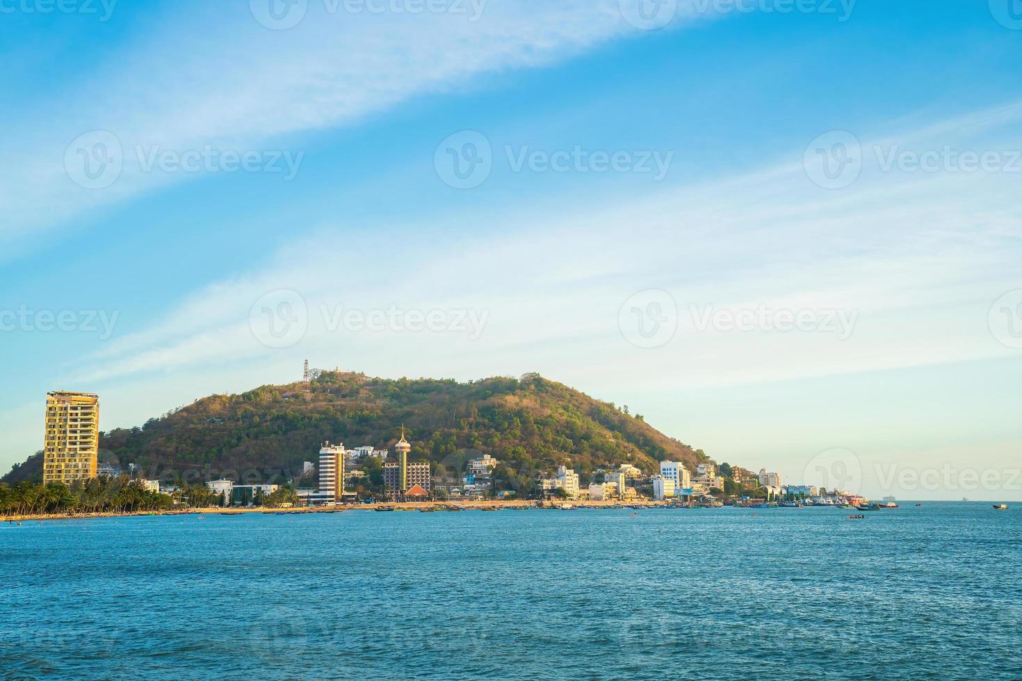 Vung Tau city aerial view with beautiful sunset and so many boats. Panoramic coastal Vung Tau view from above, with waves, coastline, streets, coconut trees and Tao Phung mountain in Vietnam. photo