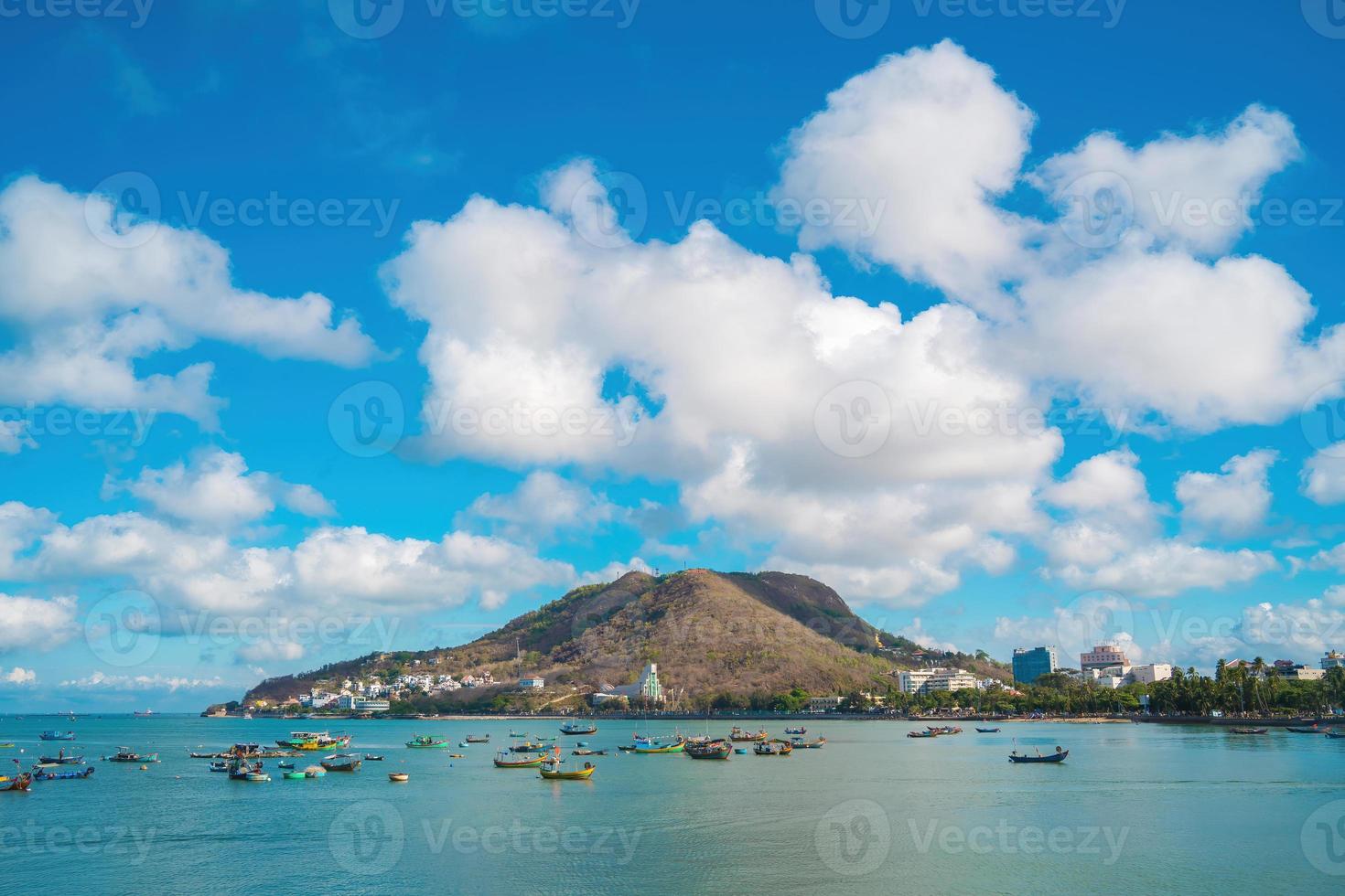 Vung Tau city aerial view with beautiful sunset and so many boats. Panoramic coastal Vung Tau view from above, with waves, coastline, streets, coconut trees and Tao Phung mountain in Vietnam. photo