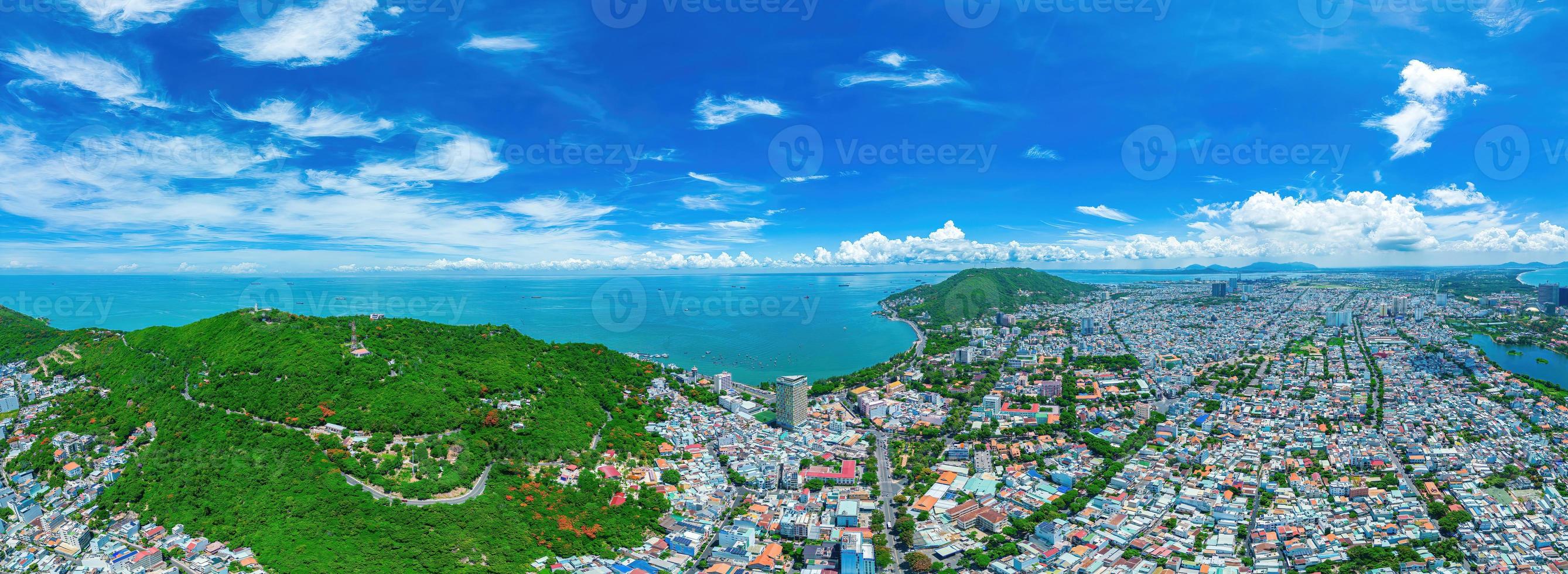 Vung Tau city aerial view with beautiful sunset and so many boats. Panoramic coastal Vung Tau view from above, with waves, coastline, streets, coconut trees and Tao Phung mountain in Vietnam. photo