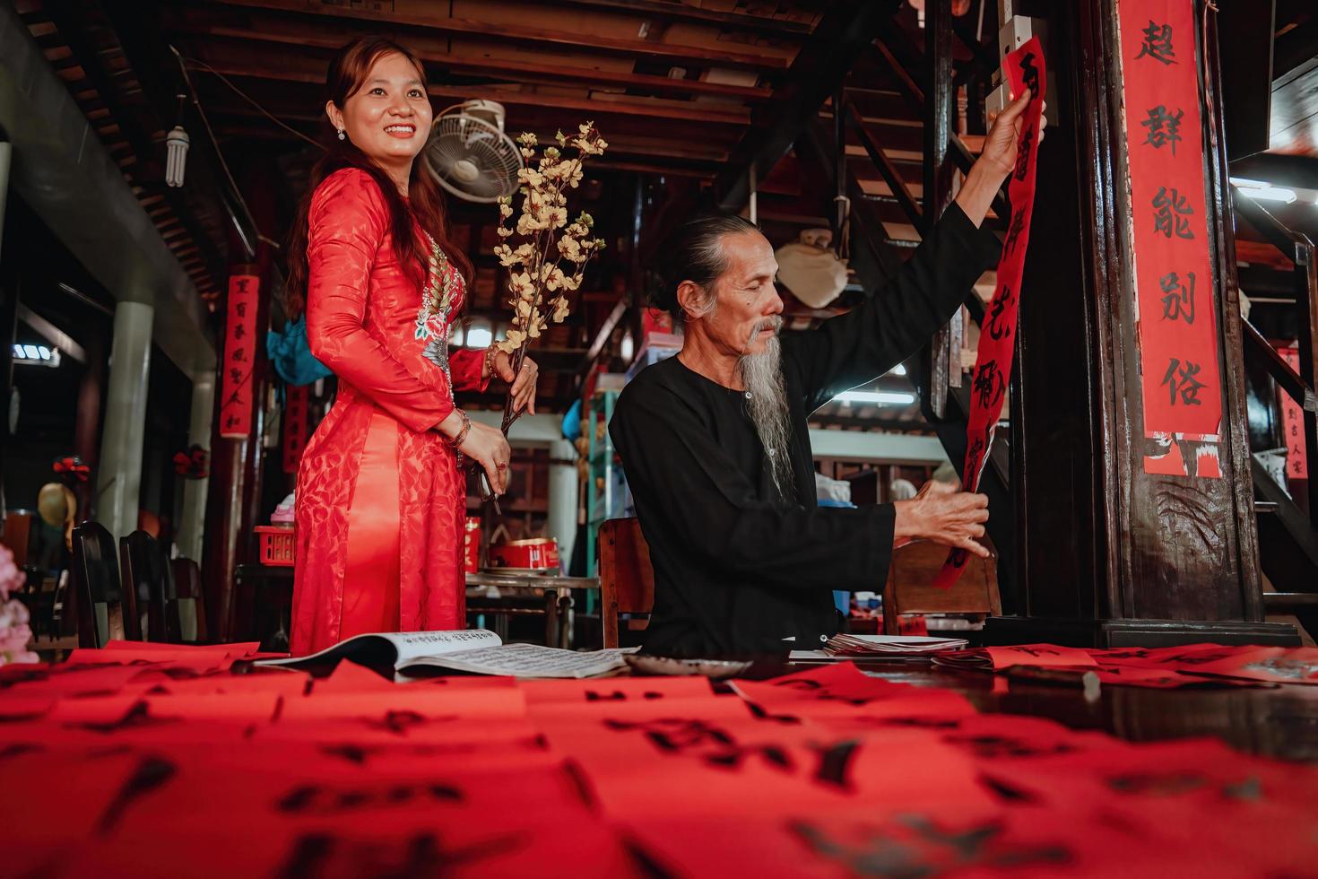 Vietnamese scholar writes calligraphy at Long Son. Calligraphy festival is a popular tradition during Tet holiday. Writing couplets for Spring Festival, new year. photo