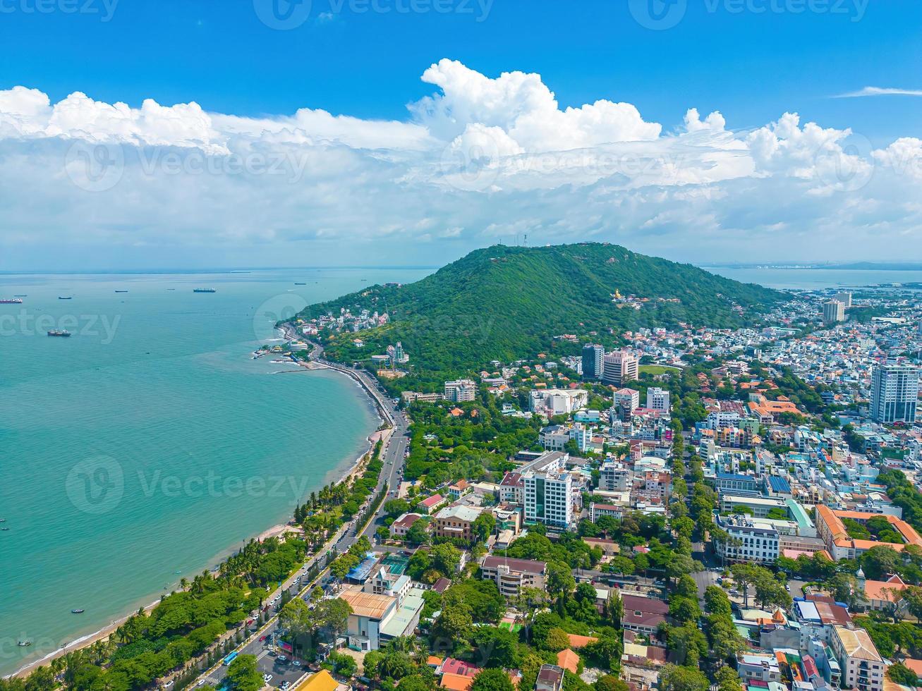 Vung Tau city aerial view with beautiful sunset and so many boats. Panoramic coastal Vung Tau view from above, with waves, coastline, streets, coconut trees and Tao Phung mountain in Vietnam. photo