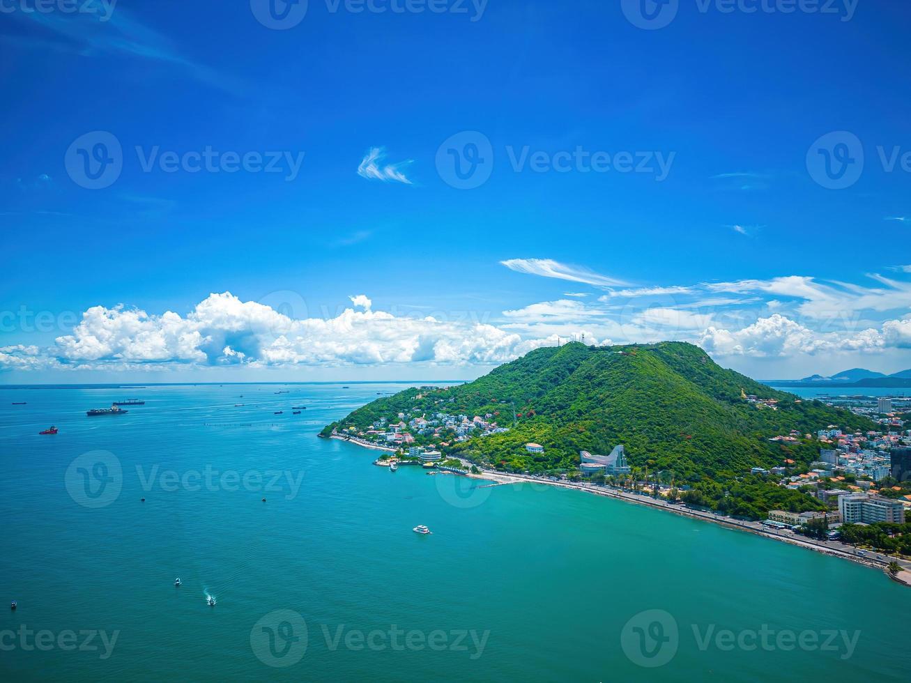 Vung Tau city aerial view with beautiful sunset and so many boats. Panoramic coastal Vung Tau view from above, with waves, coastline, streets, coconut trees and Tao Phung mountain in Vietnam. photo