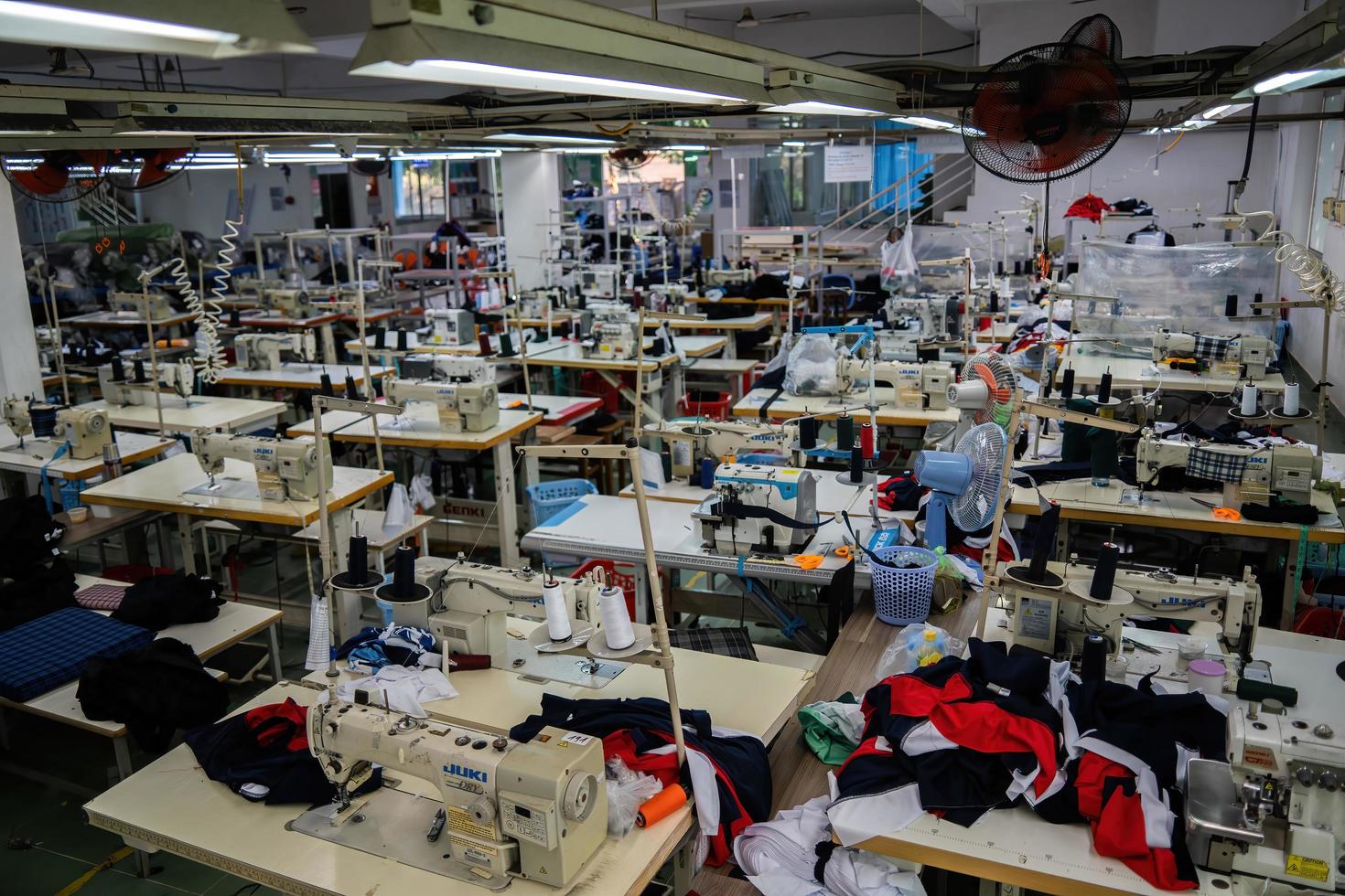 Ba Ria, VIETNAM - MAR 18 2022 Textile cloth factory working process tailoring workers equipment. This is a sewing machine factory production empty worker. photo