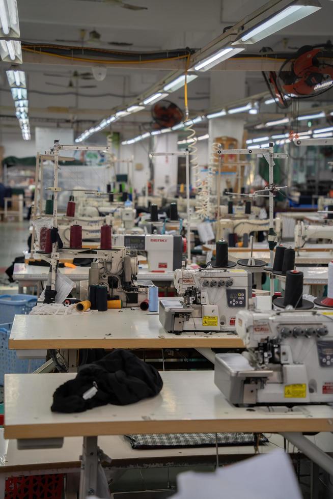 Ba Ria, VIETNAM - MAR 18 2022 Textile cloth factory working process tailoring workers equipment. This is a sewing machine factory production empty worker. photo