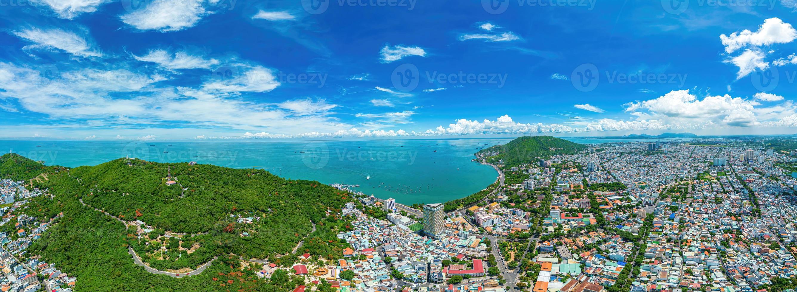 Vung Tau city aerial view with beautiful sunset and so many boats. Panoramic coastal Vung Tau view from above, with waves, coastline, streets, coconut trees and Tao Phung mountain in Vietnam. photo