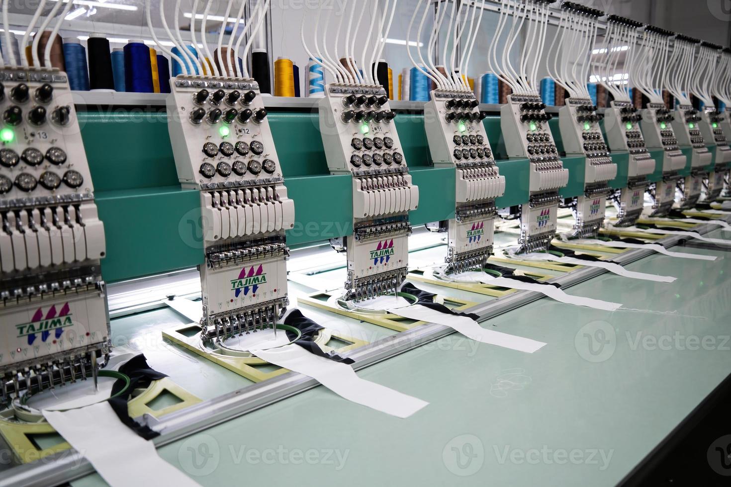 Modern and automatic high technology sewing machine for textile or clothing apparel making manufacturing process in industrial. Digital textile industry. Computerized embroidery. photo