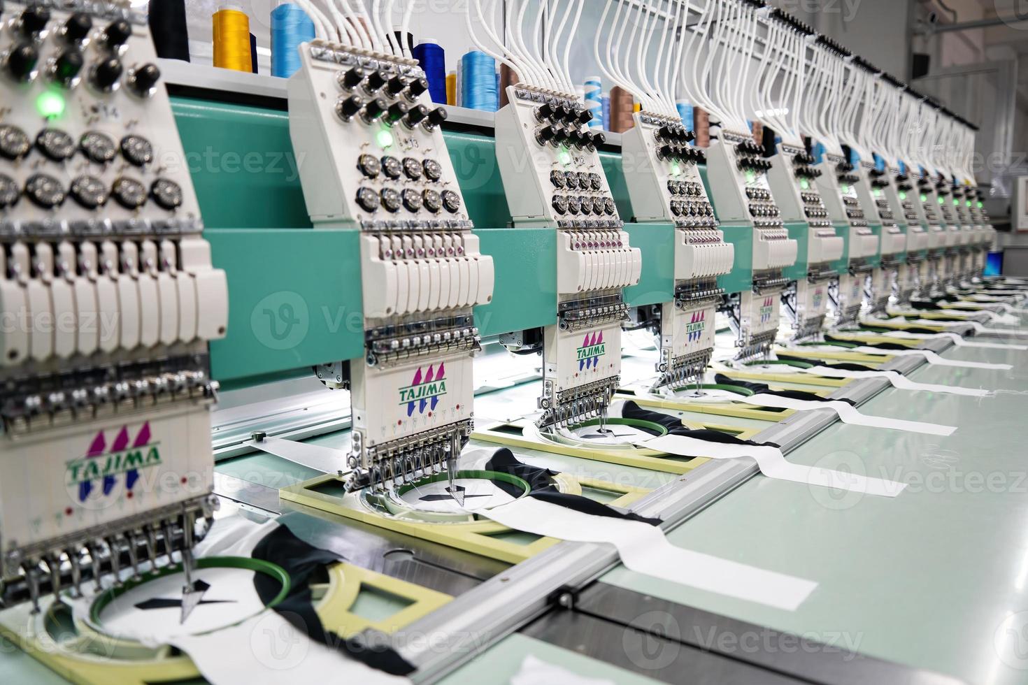 máquina de coser moderna y automática de alta tecnología para el proceso de fabricación de prendas de vestir o textiles en la industria. industria textil digital. bordado computarizado. foto