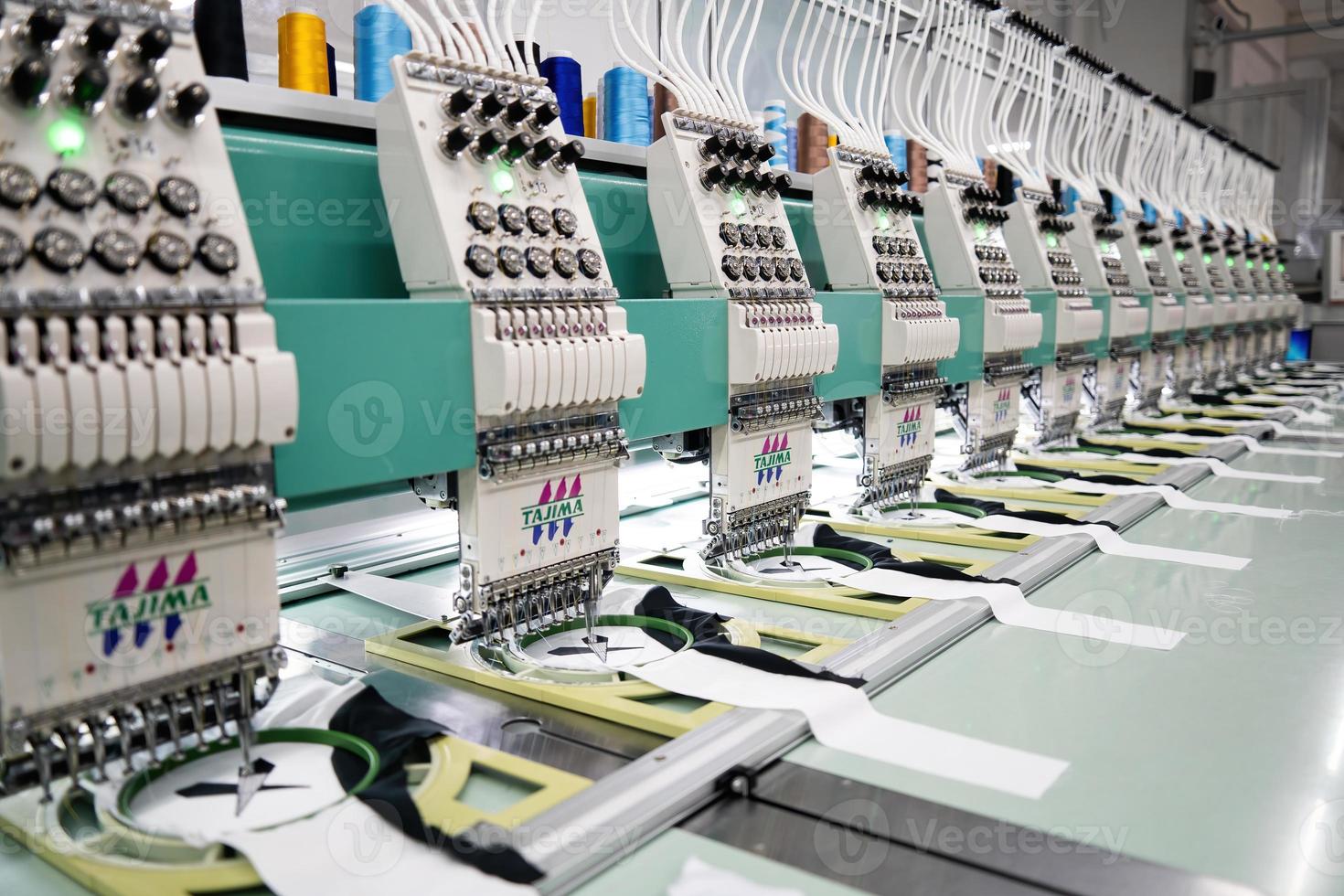 Modern and automatic high technology sewing machine for textile or clothing apparel making manufacturing process in industrial. Digital textile industry. Computerized embroidery. photo