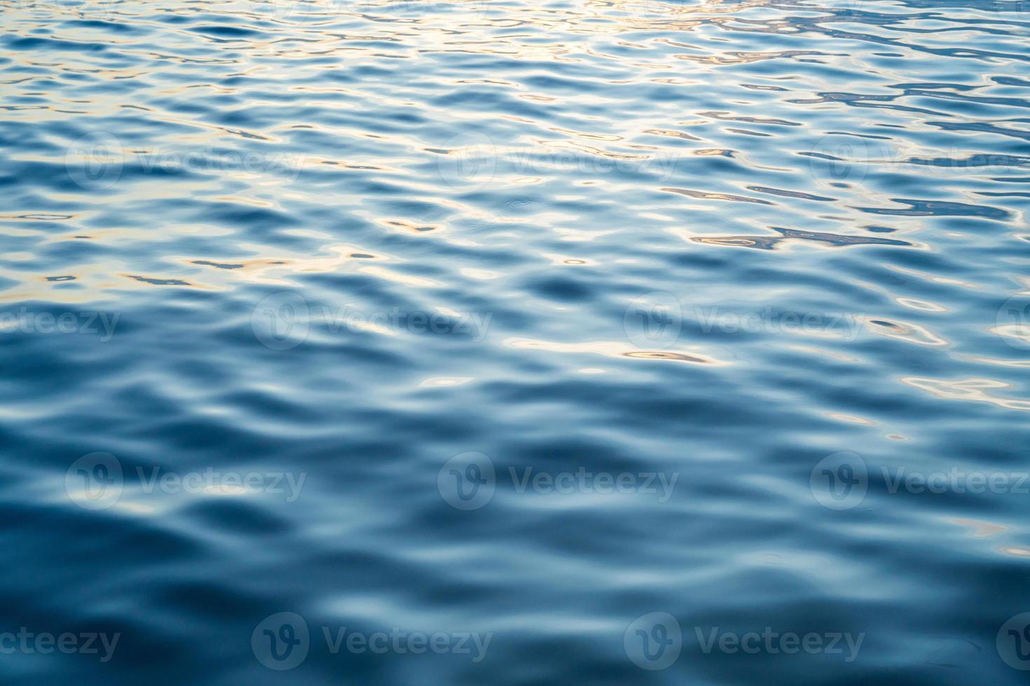 Sunset water reflect ripples at sun light. Abstract golden reflection on water sunset photo