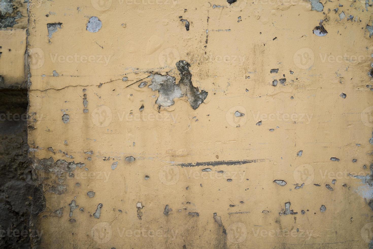 Texture of old yellow concrete wall for background.  Rough texture on yellow wall rough form due to peeling paint layer due to rain. photo