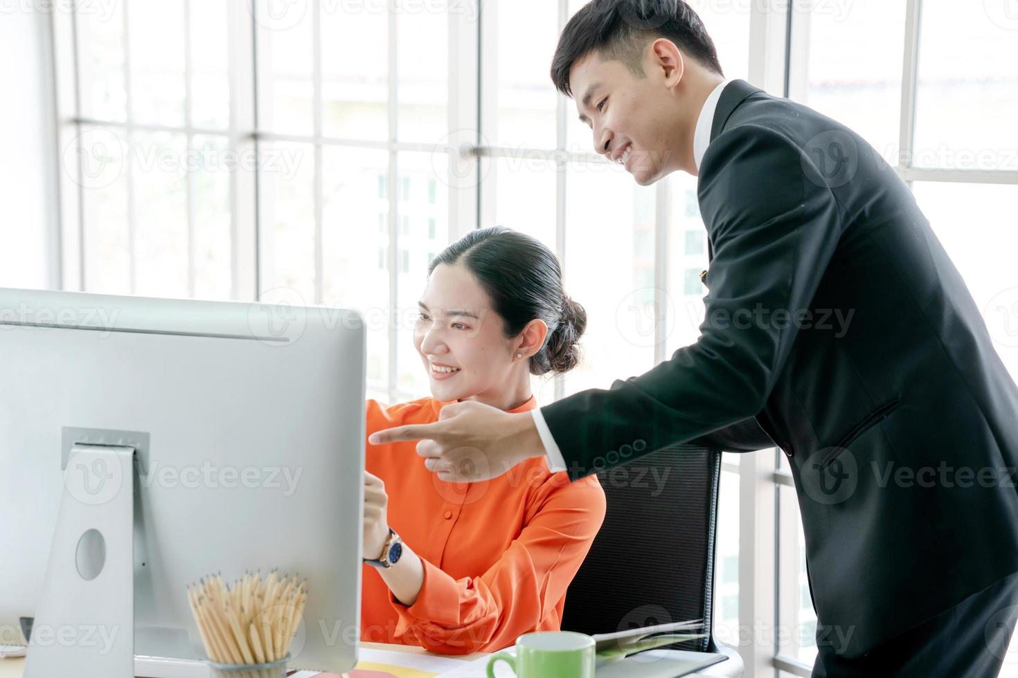 Two young business people analyzing graphs during photo