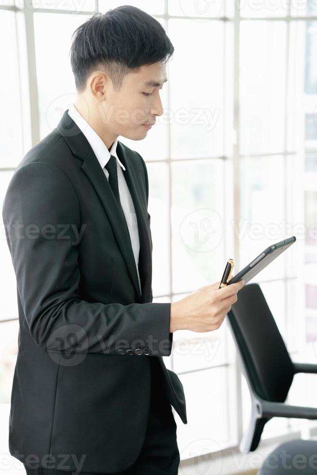 Portrait of a young businessman using a digital tablet in a modern office photo
