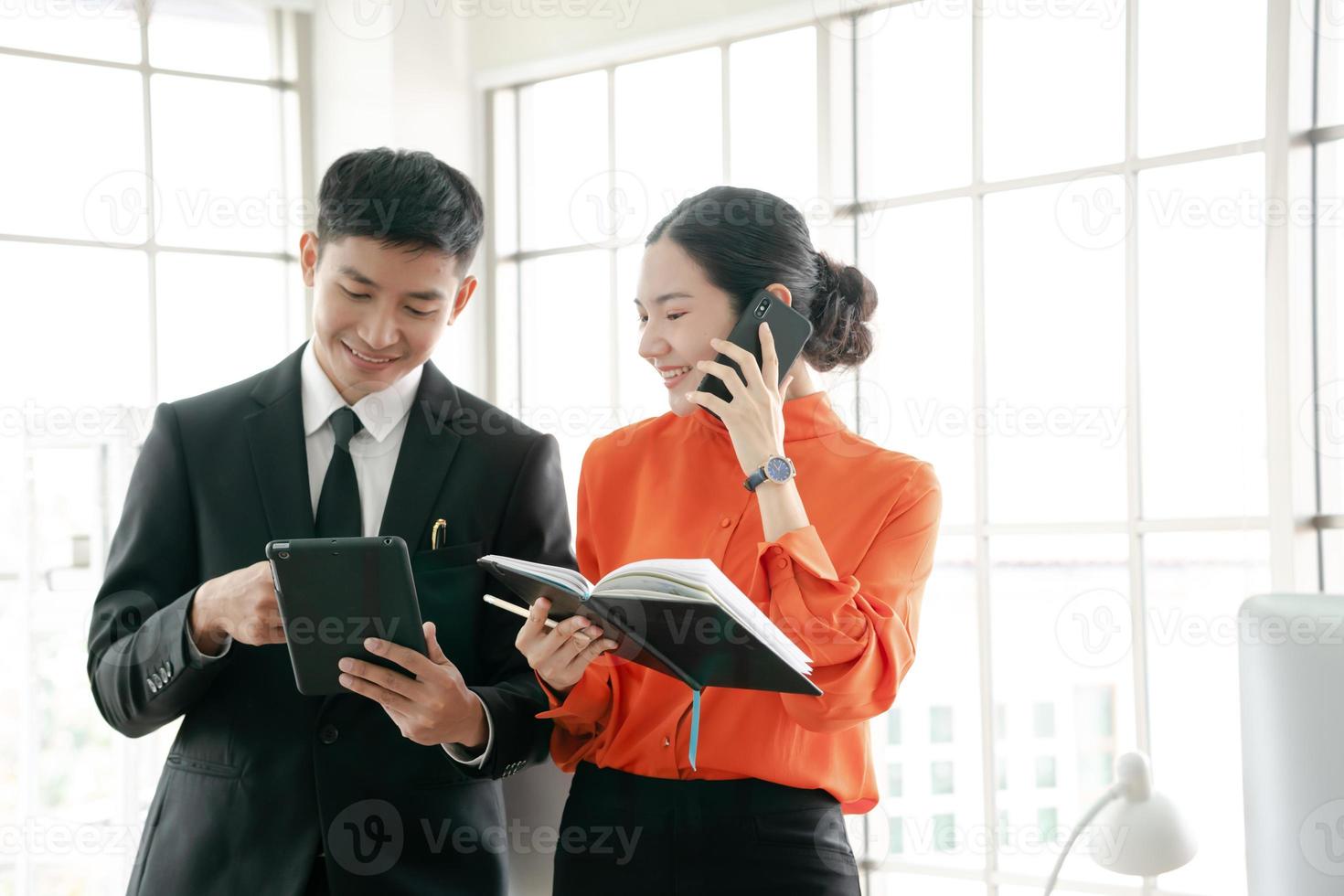 Business man and woman on steps talking on mobile phone to customer photo