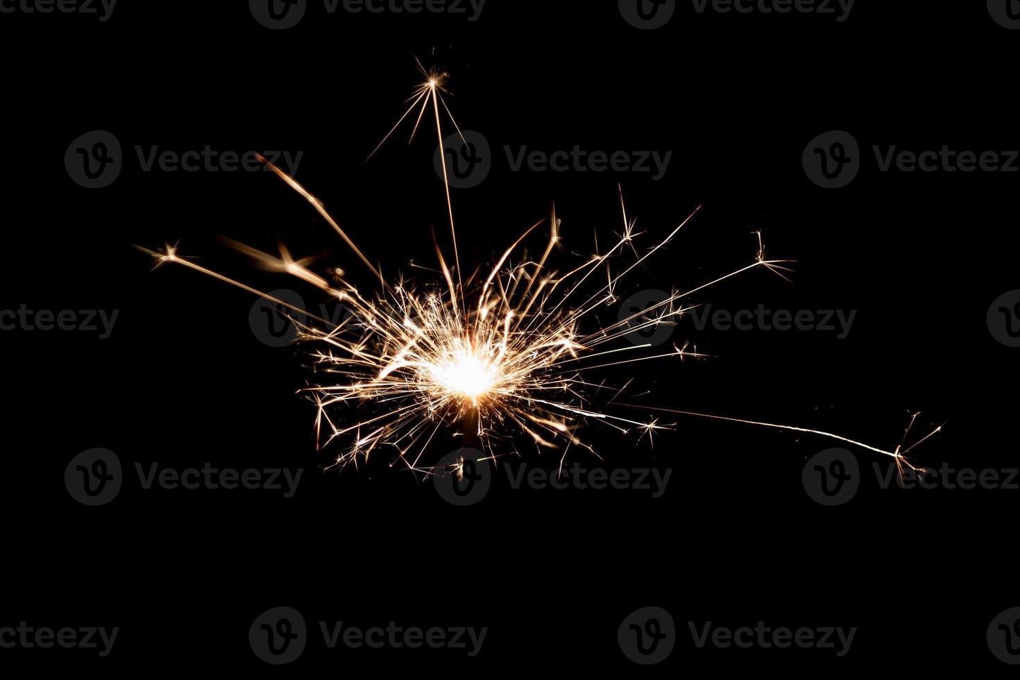 Burning sparkler isolated on black background. Fireworks theme. Light effect and texture. photo