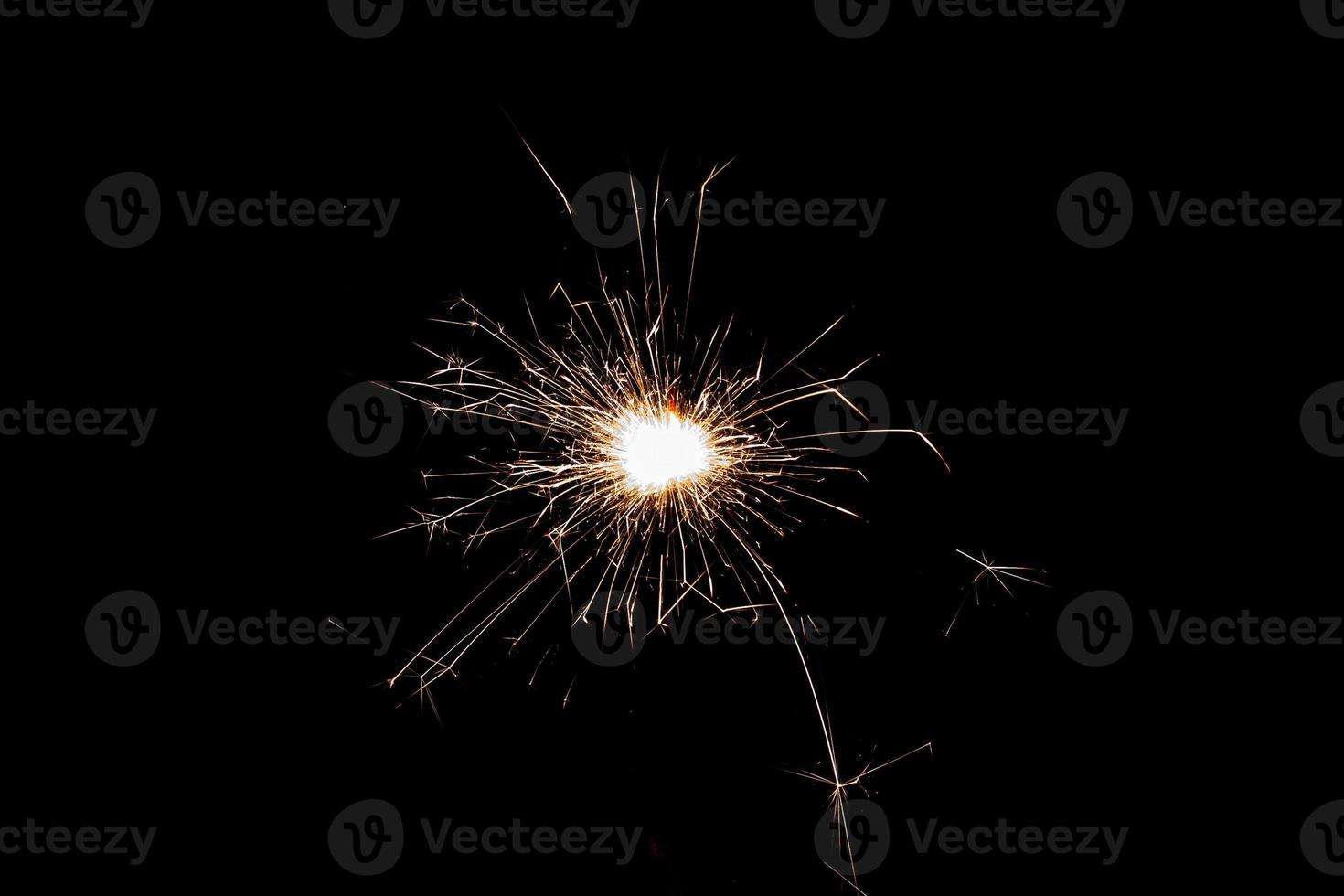 Burning sparkler isolated on black background. Fireworks theme. Light effect and texture. photo