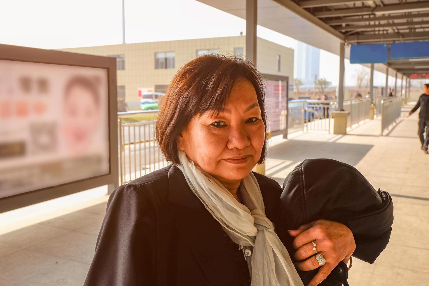 Portrait Old asian women in yiwu bus terminal when she arrive to yiwu city china photo