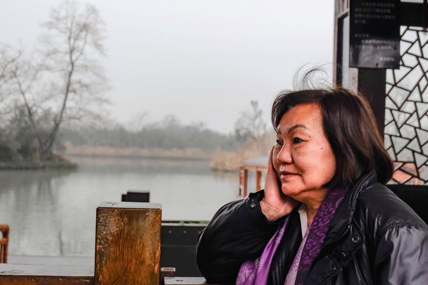 Beautiful Old asian women traveler very relax and tranquil in the park of hangzhou city china photo