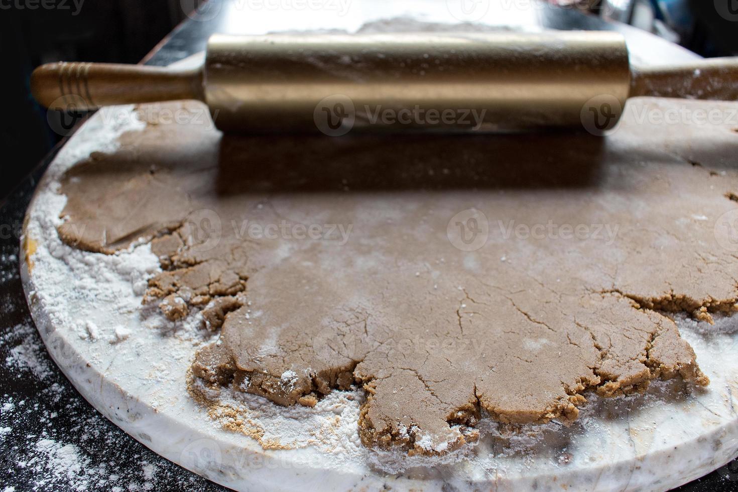 masa de pan de jengibre en mármol redondo con rodillo de oro foto