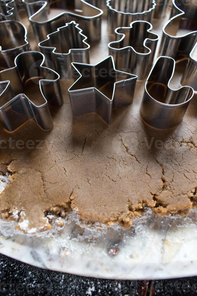 cortadores de galletas de navidad en masa de pan de jengibre foto