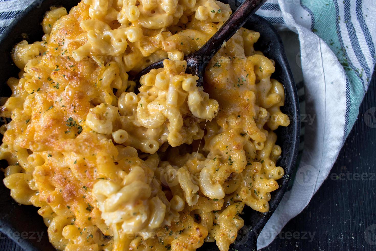 gourmet baked macaroni and cheese noodles in rustic cast iron dish flat lay photo