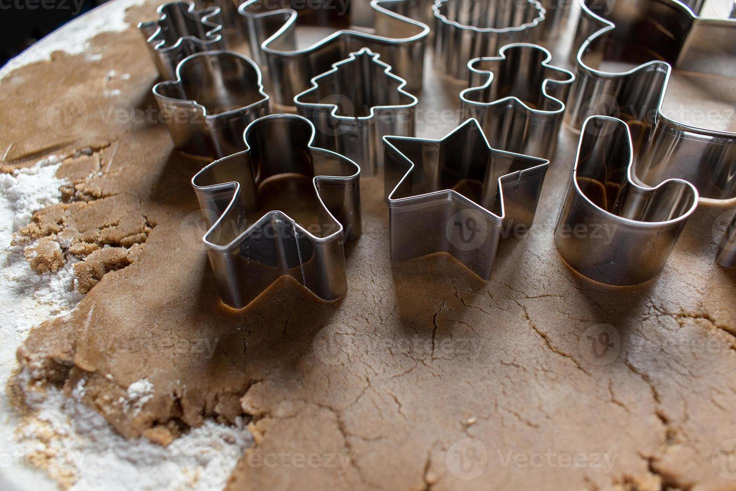 cortadores de galletas de navidad en masa de pan de jengibre foto