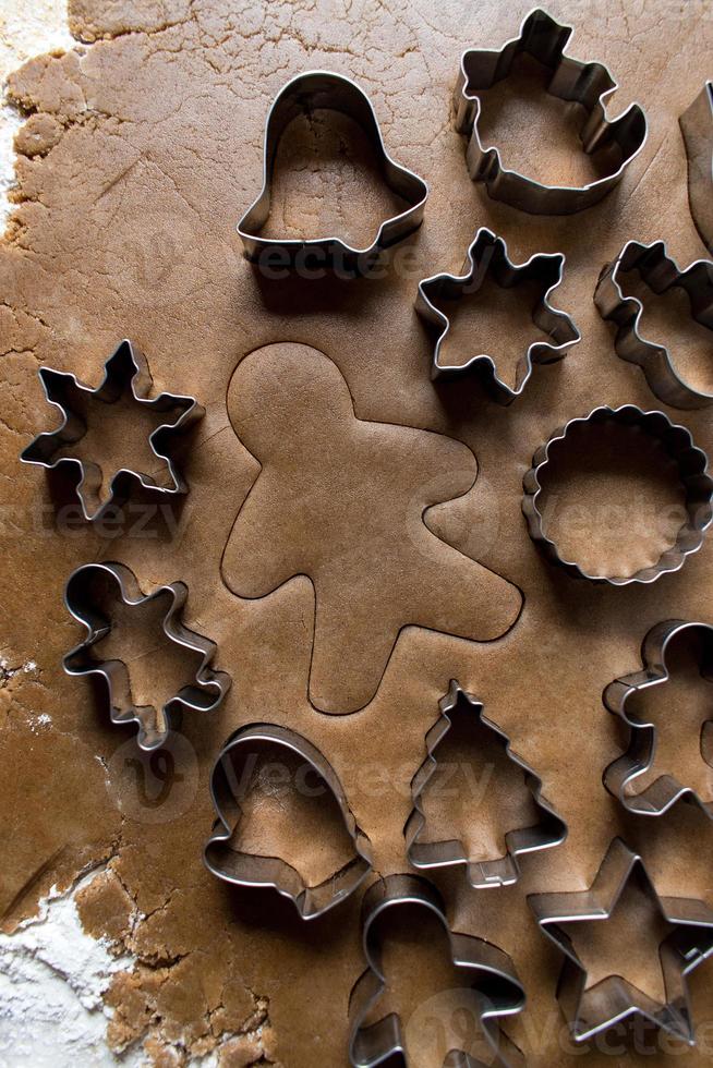 Christmas cookie cutters on gingerbread dough flat lay photo